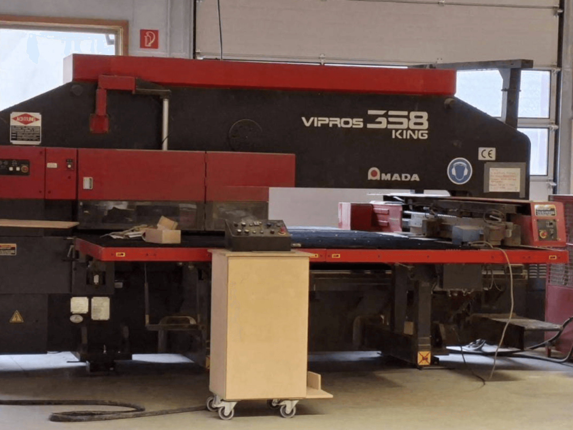 CNC děrovací lis AMADA VIPROS 358 KING v bočním pohledu, s ovládacím panelem a prostorem pro uložení nástrojů.