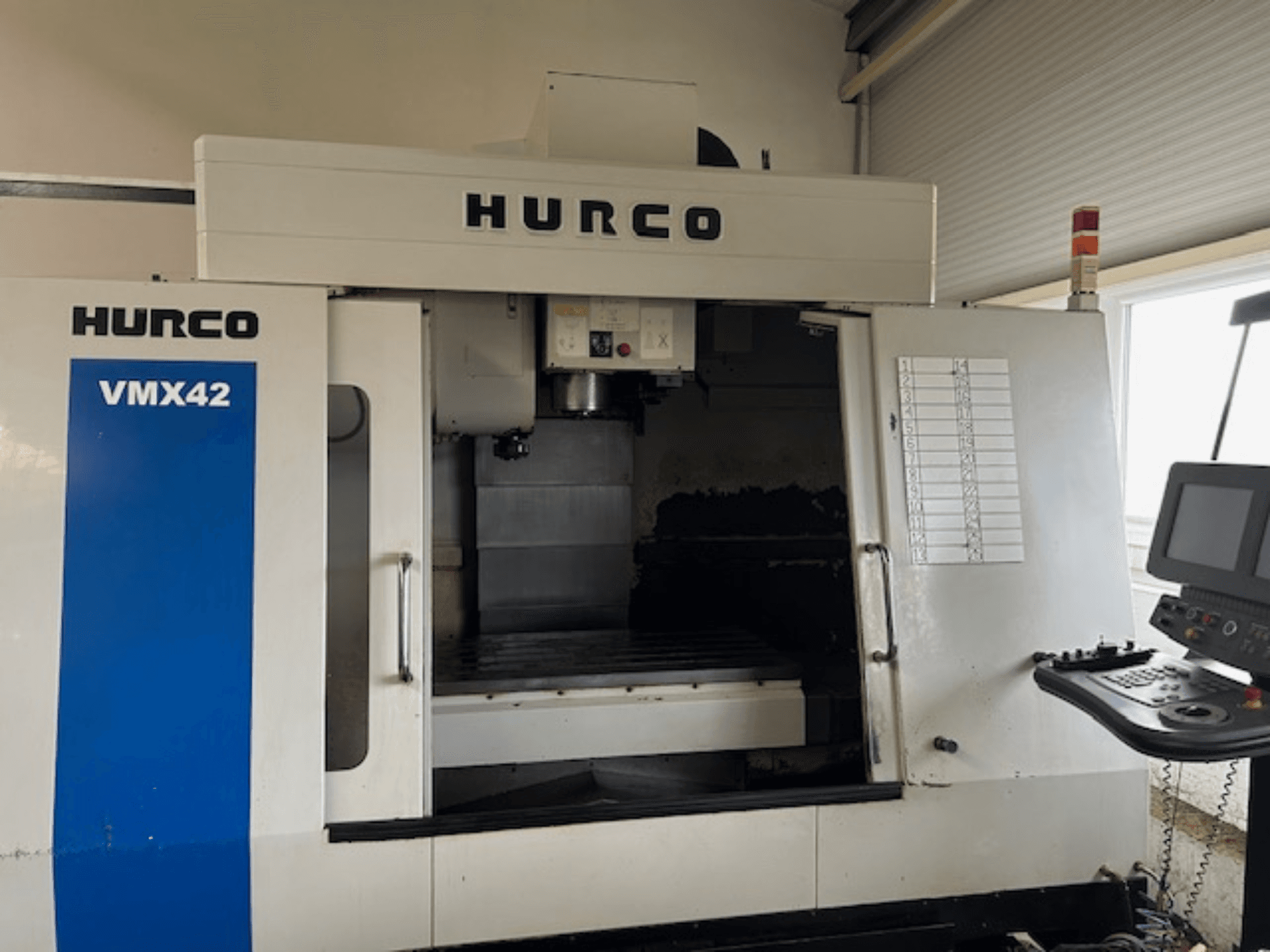 CNC stroj Hurco VMX42 v čelním pohledu, zobrazující ovládací panel, vřeteno a pracovní plochu; odhalující provozní uspořádání.