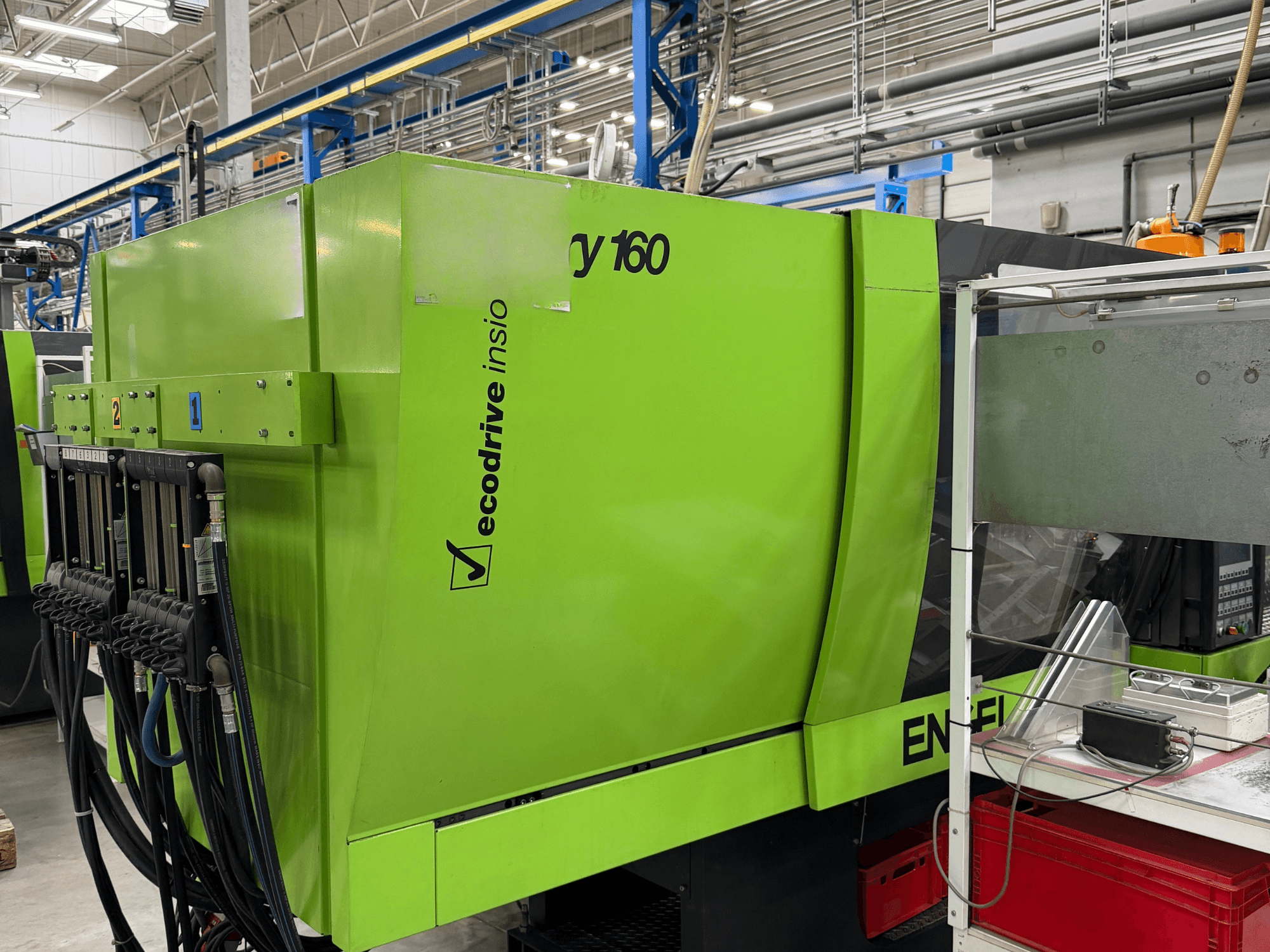 Hydraulický vstřikovací lis Engel Victory 500/160 v zelené barvě, boční pohled znázorňující ovládací panel a funkci Ecodrive.