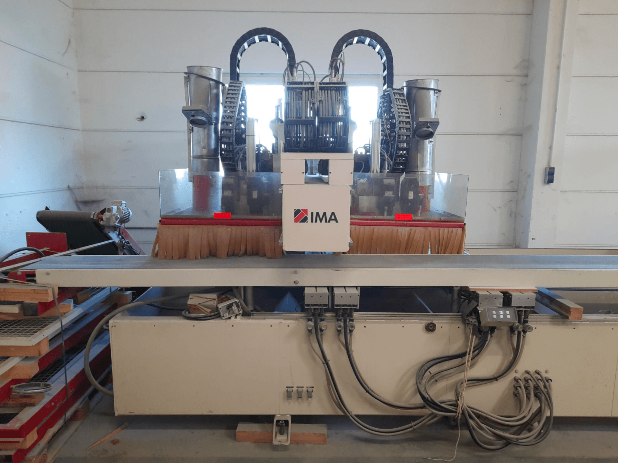 CNC dřevoobráběcí centrum IMA BIMA 610 V zobrazené zepředu, s kartáči, ovládacími prvky a pracovním stolem.