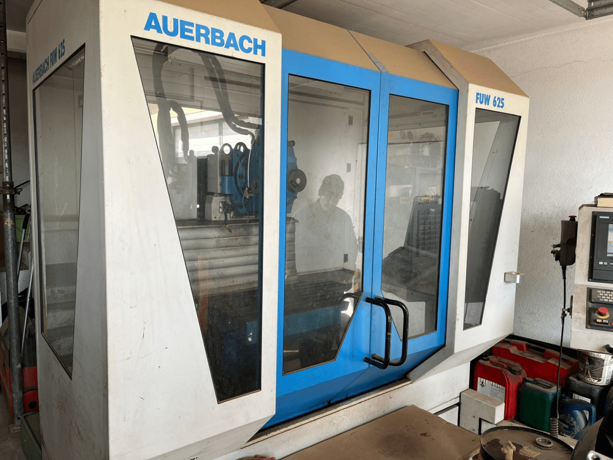 Univerzální obráběcí centrum Auerbach FUW 625 v bočním pohledu, se skleněnými panely a ovládacím panelem vpravo.