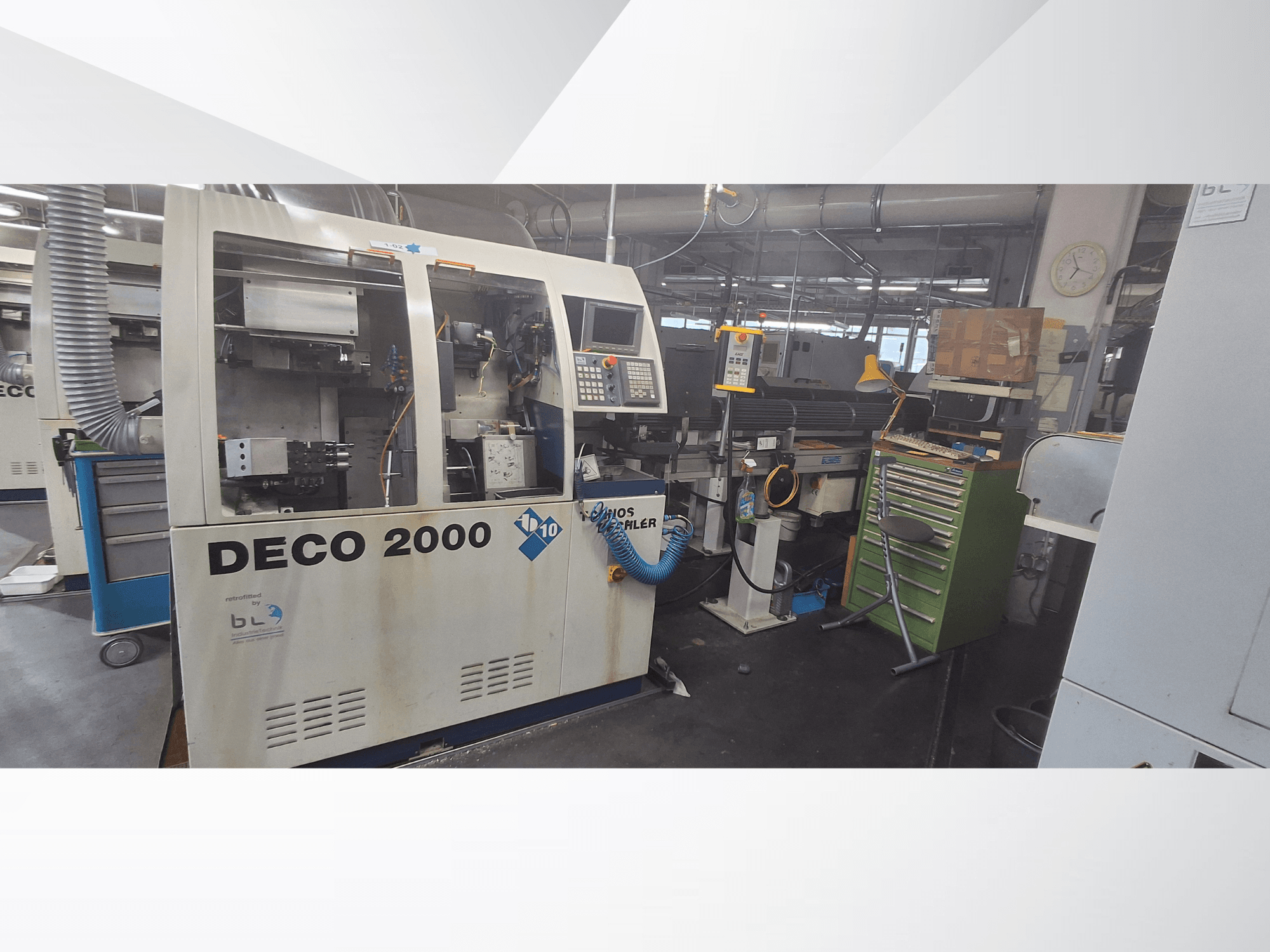 Švýcarský soustruh TORNOS DECO 2000-10, pohled zepředu, znázorňující ovládací panel a nakládací prostor v dílenském prostředí.