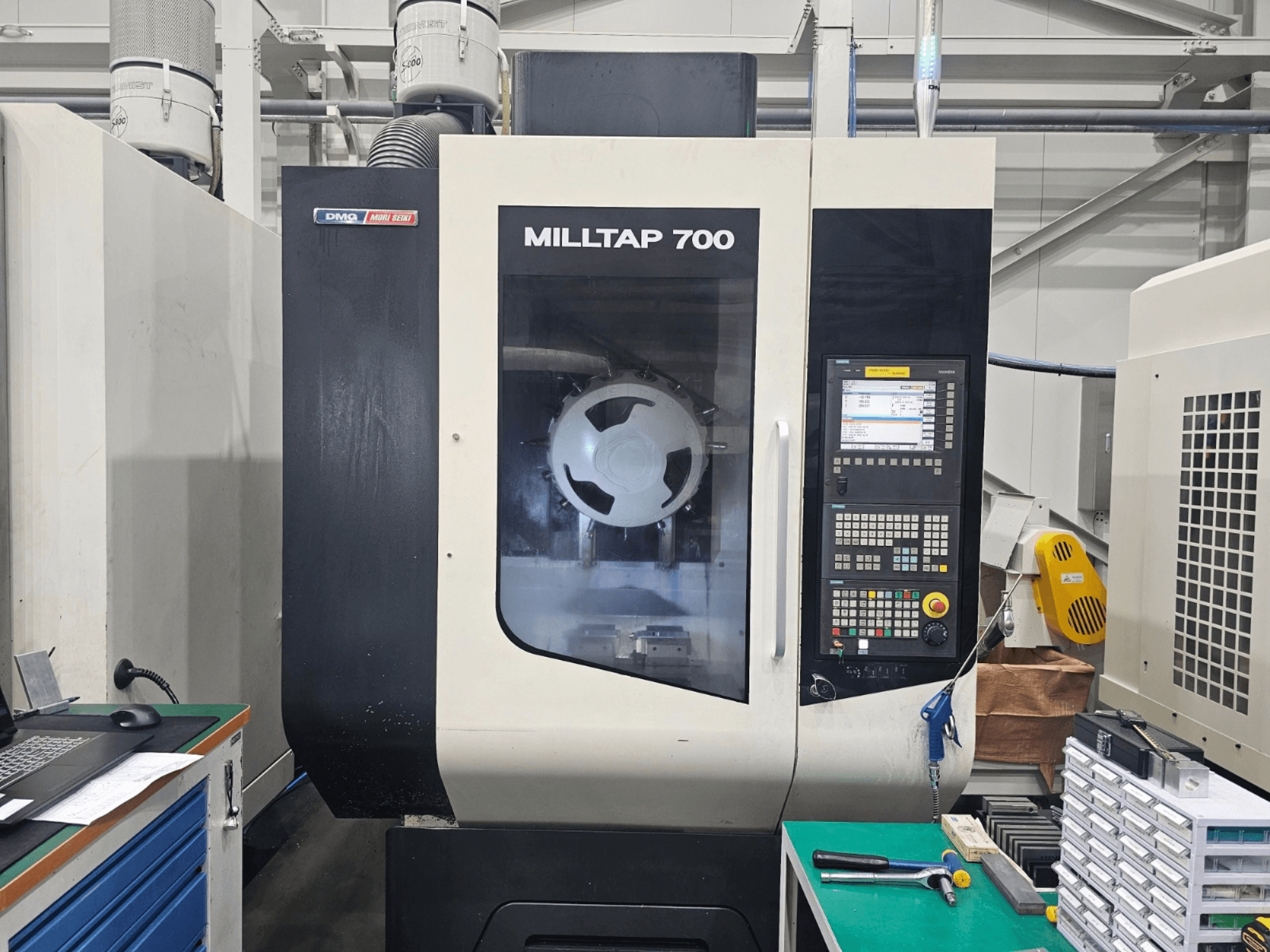 Vertikální obráběcí centrum DMG MORI MILLTAP 700, pohled zepředu, na kterém jsou vidět ovládací panel, vřeteno a detaily pracovní plochy.