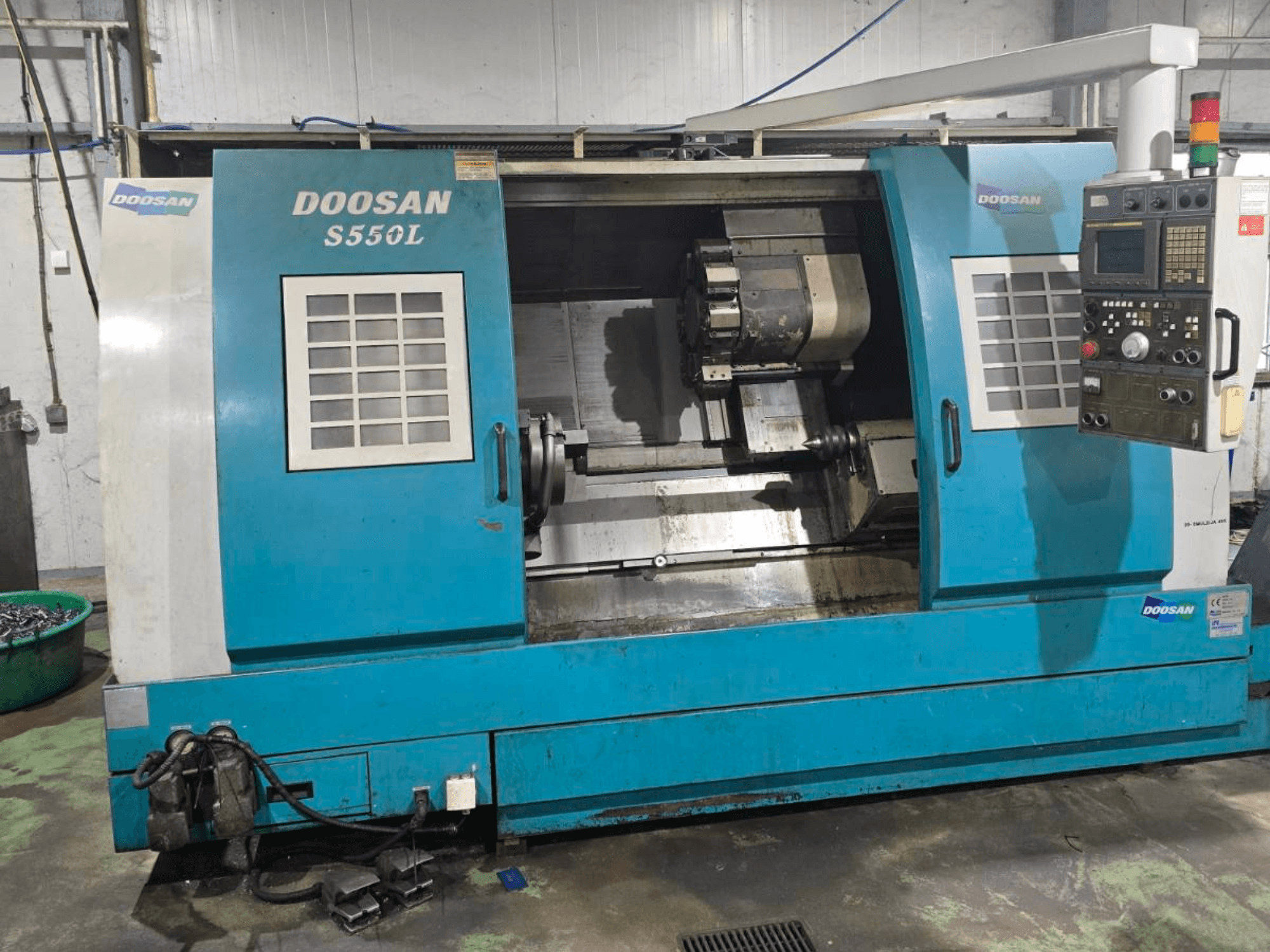 Horizontální soustruh DOOSAN S550L v bočním pohledu, s ovládacím panelem a soustružnickým ložem, ideální pro přesné obrábění.