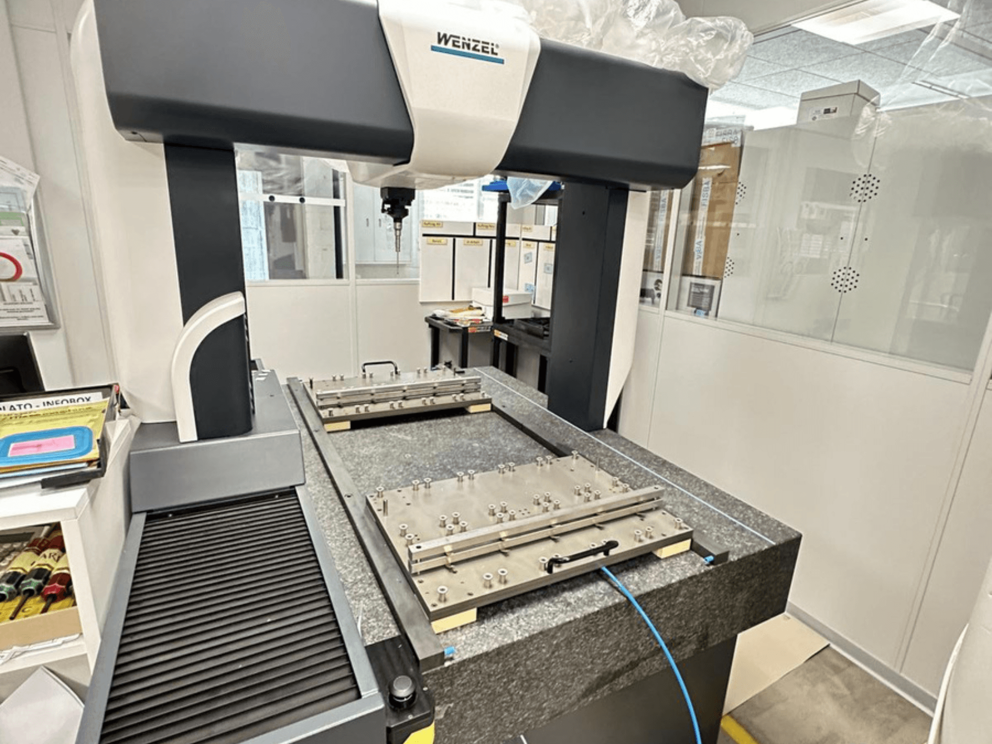 Koordinátový měřicí stroj Wenzel LH 65 v laboratorním prostředí, na snímku je vidět žulová základna s nastavitelnou měřicí plošinou a horním ramenem.