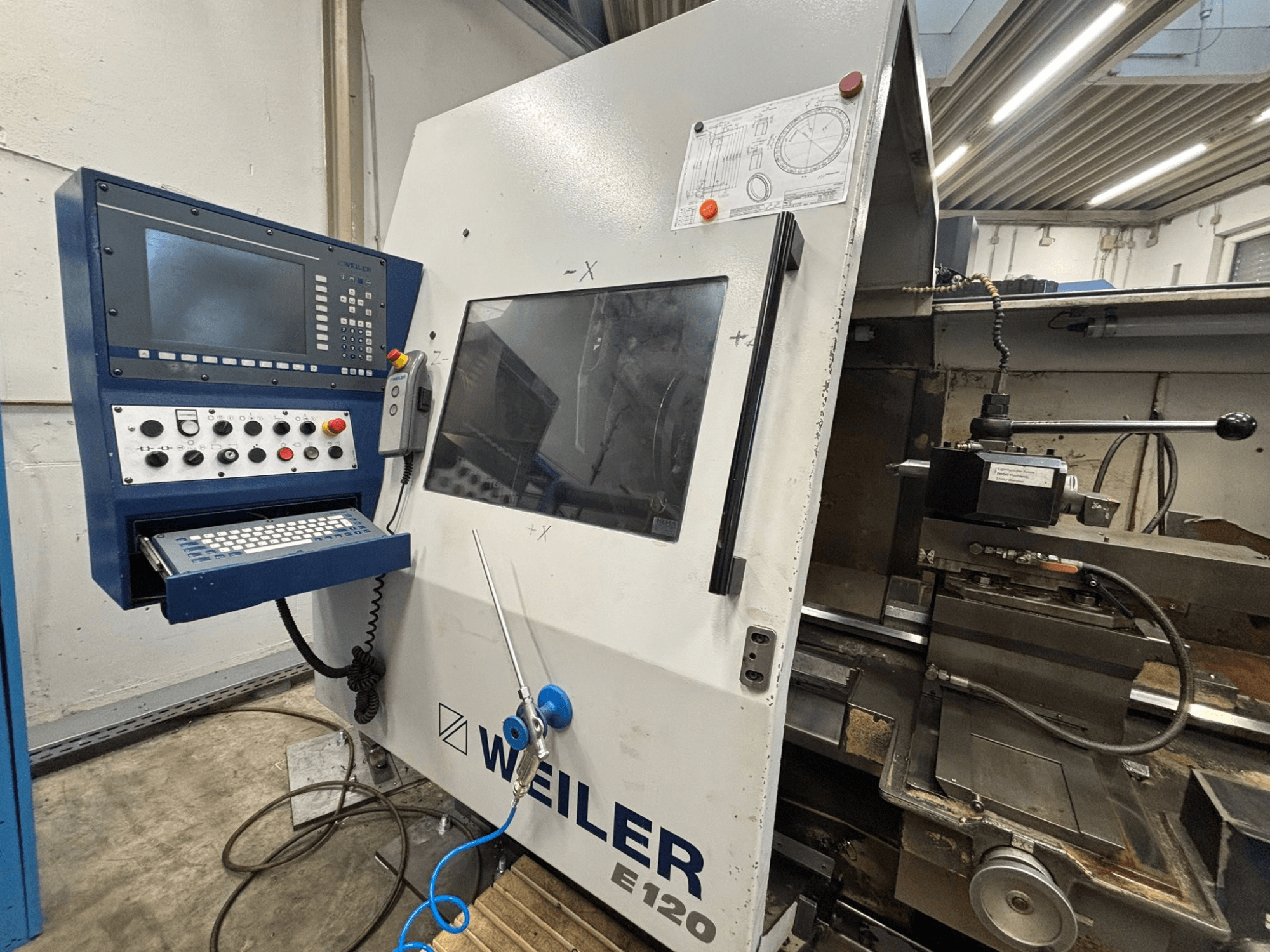 Ovládací panel a rozhraní stroje Weiler E-120 CNC, pohled zepředu s viditelnými tlačítky, obrazovkou a ovládacími prvky.