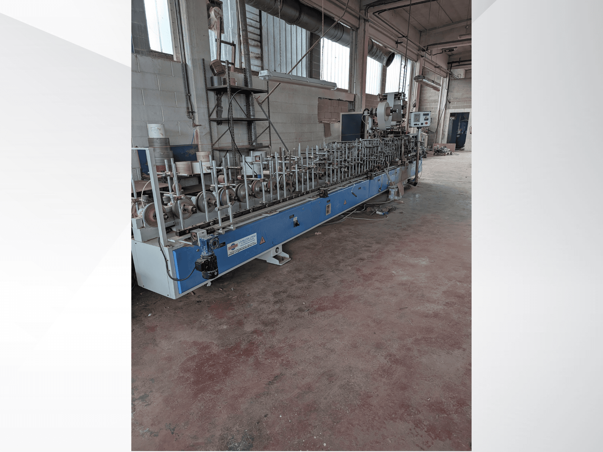 Pohled zepředu na stroj na dřevo PUR-33-L s několika vřeteny a elegantním modrým designem v průmyslovém prostředí.