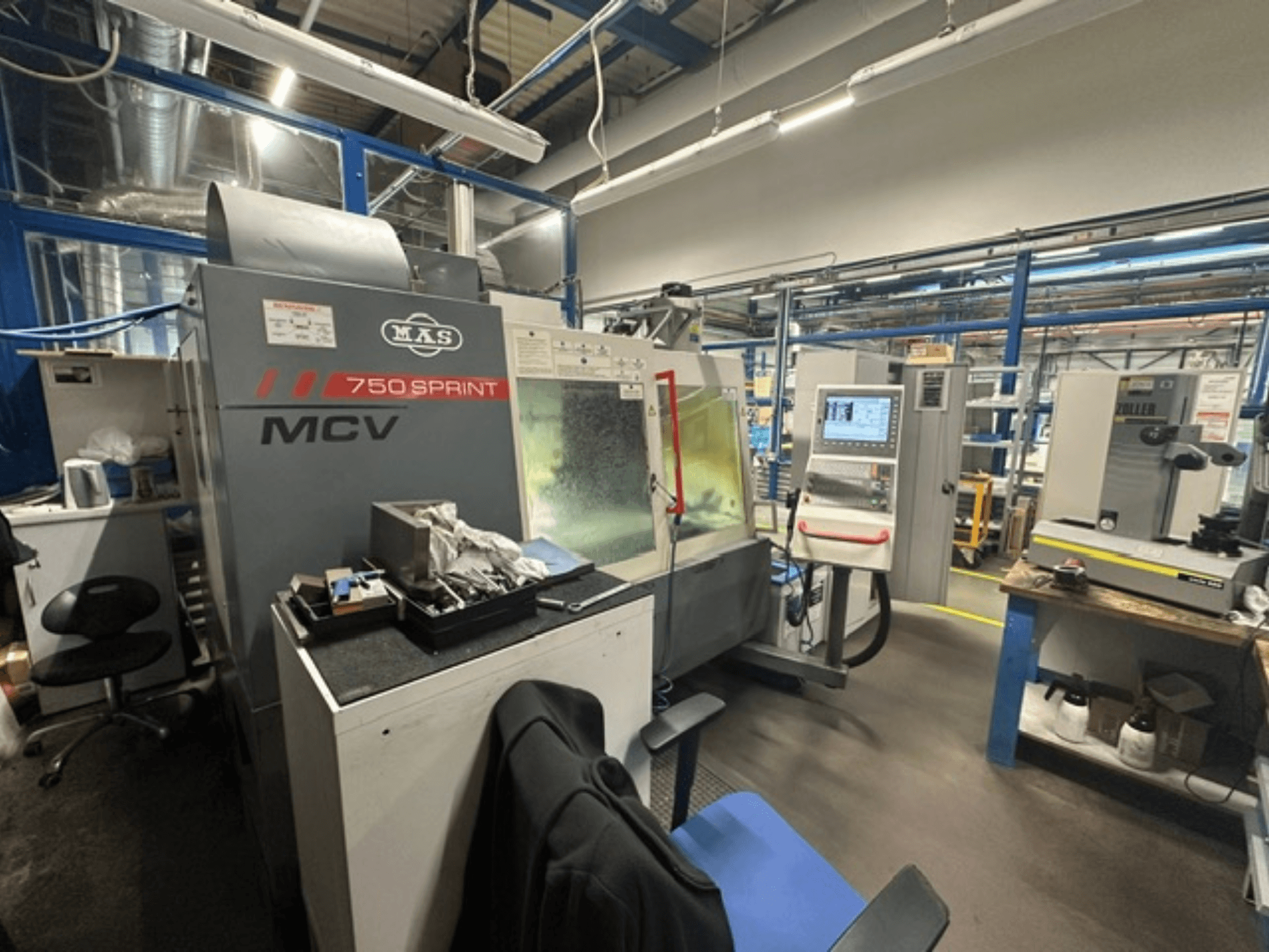 Vertikální obráběcí centrum KOVOSVIT MAS MCV 750 Sprint v dílně; na snímku je z bočního pohledu vidět ovládací panel a pracovní prostor.