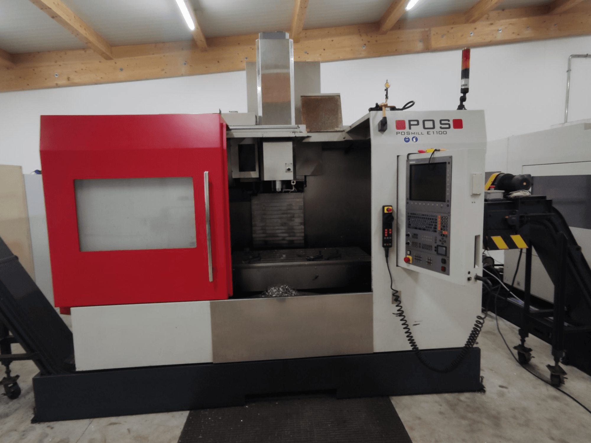 Frézka POS POSMILL E1100 CNC v čelním pohledu s červeným krytem, ovládacím panelem a bezpečnostním světlem nahoře.