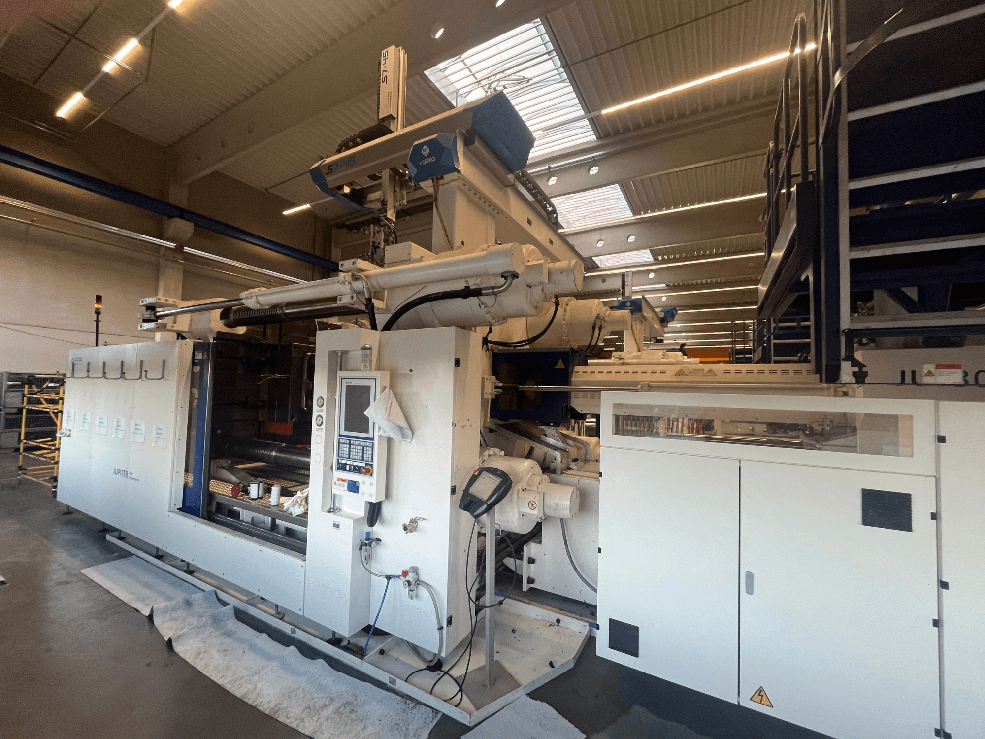 Pohled na textilní stroj Autefa zepředu, ovládací panel, komponenty a průmyslové nastavení.