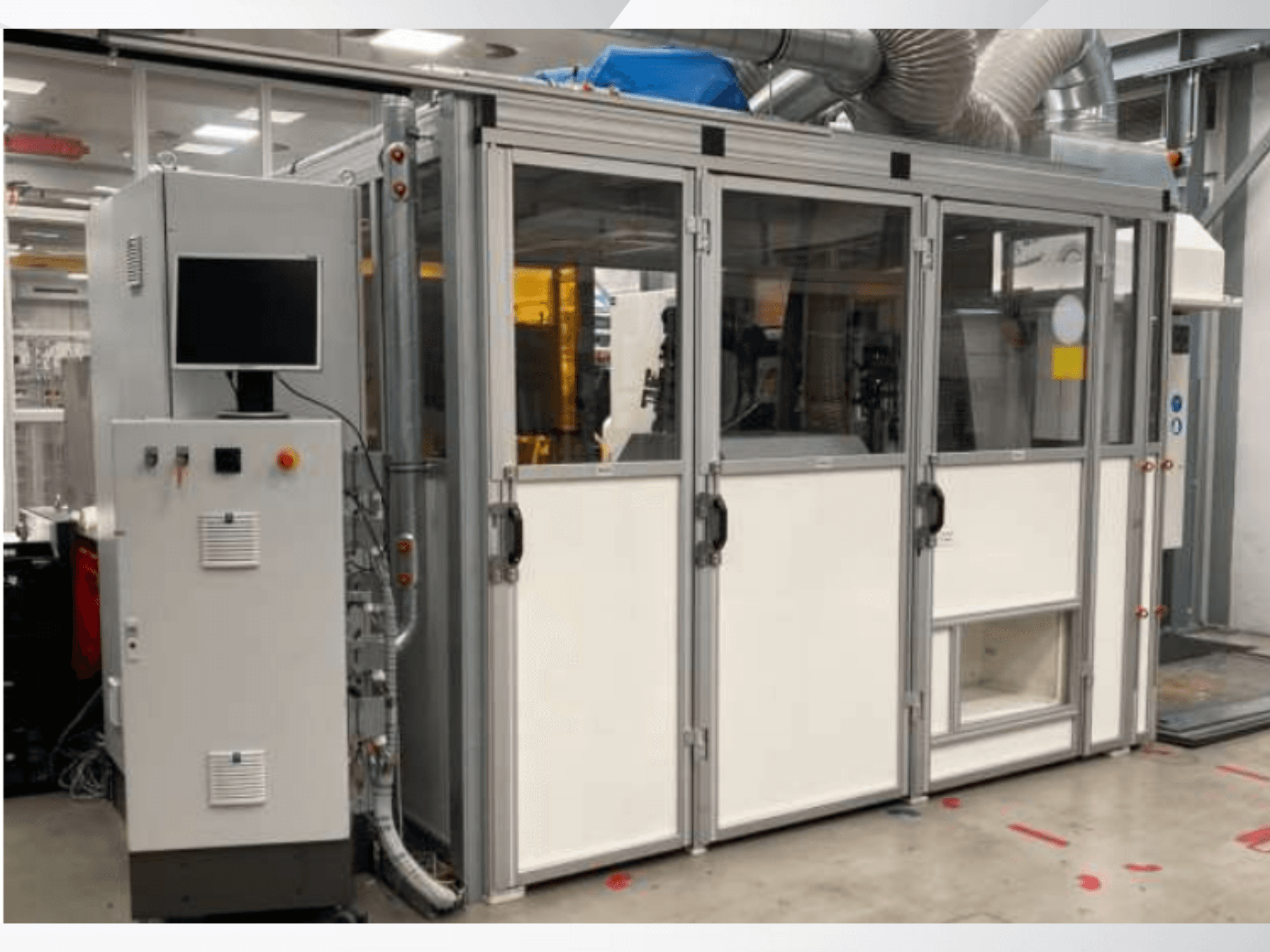 Průmyslový stroj s ovládacím panelem, pohled zepředu; prosklené dveře, ventilační kanály a viditelná kabeláž.