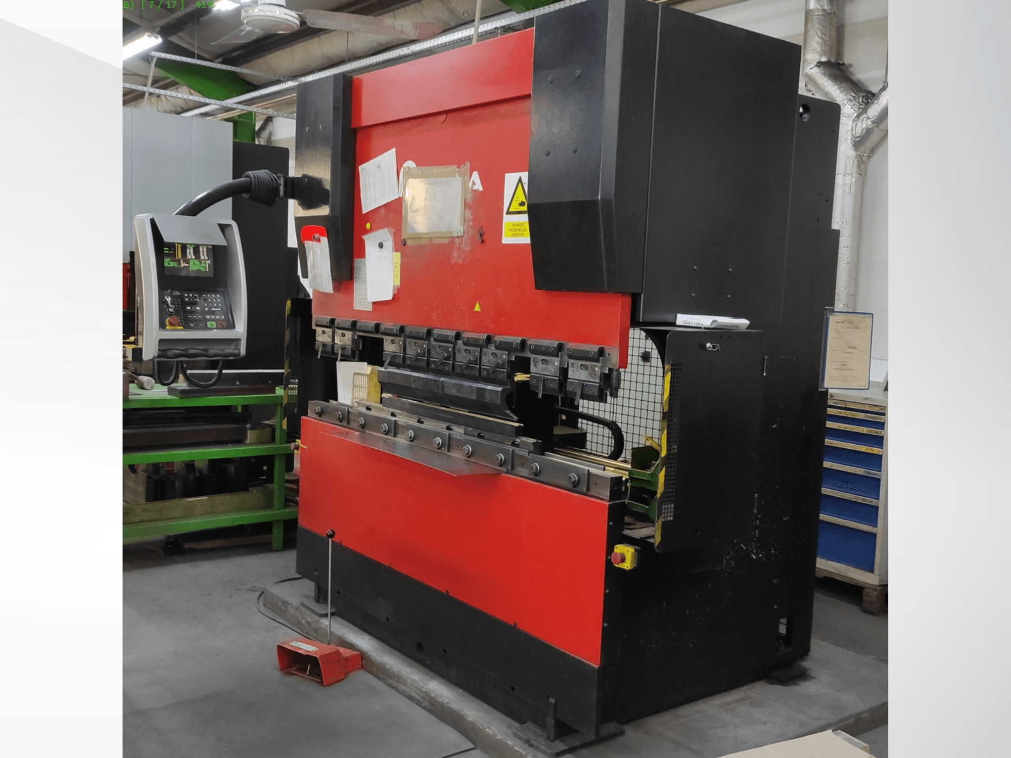 Lisovací brzda AMADA HFB 5020 v červeno-černém provedení, pohled zepředu, zobrazující ovládací panel, ohýbací nástroje a bezpečnostní prvky.