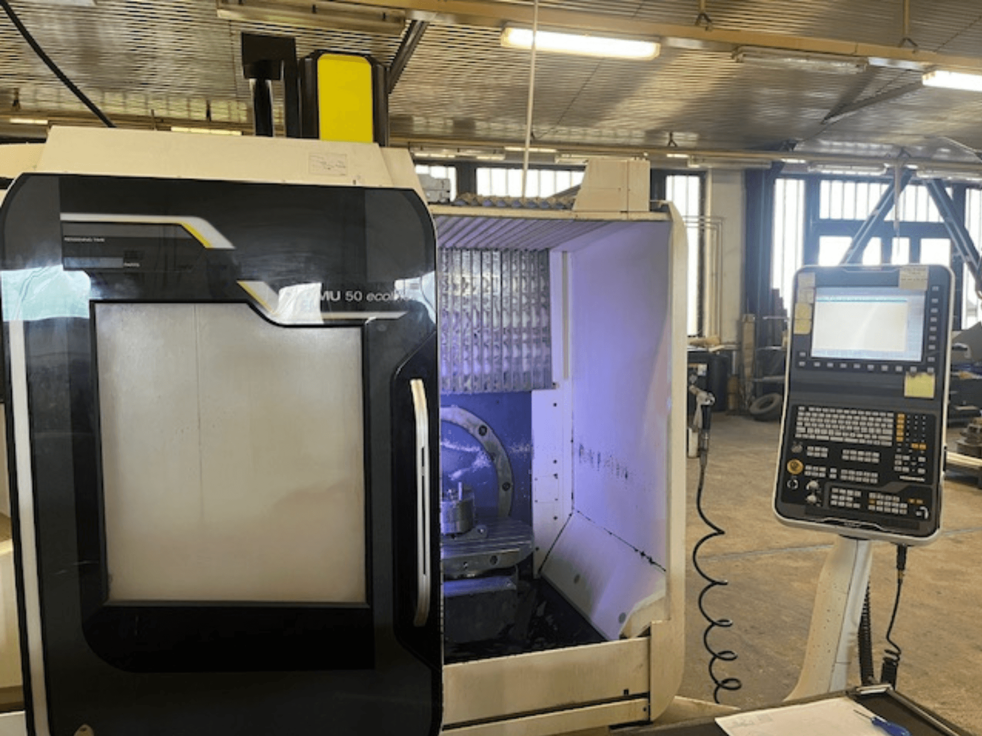 Frézka DMU 50 eco pohled zepředu s ovládacím panelem, zobrazením držáku nástrojů a pracovního prostoru.