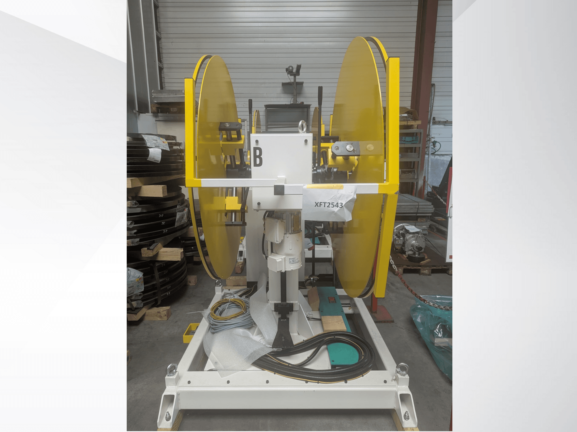 Žluté kotoučové pily namontované na bílém podstavci stroje, pohled zepředu; model XFT2543, s viditelnou kabeláží a součástmi.