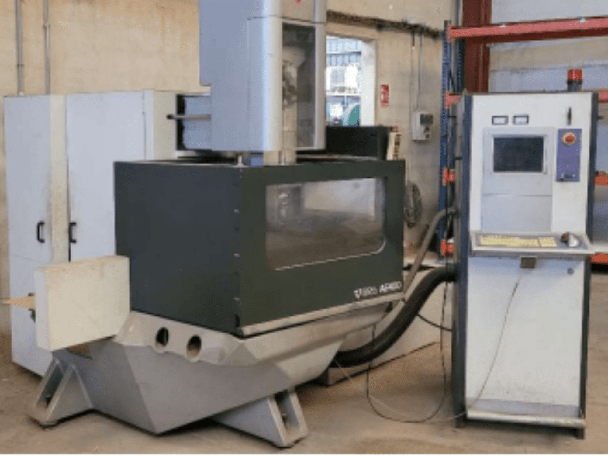 Drátový elektroerozivní stroj ONA AE 400 v dílenském prostředí, s ovládacím panelem vpravo a velkým řezným prostorem.