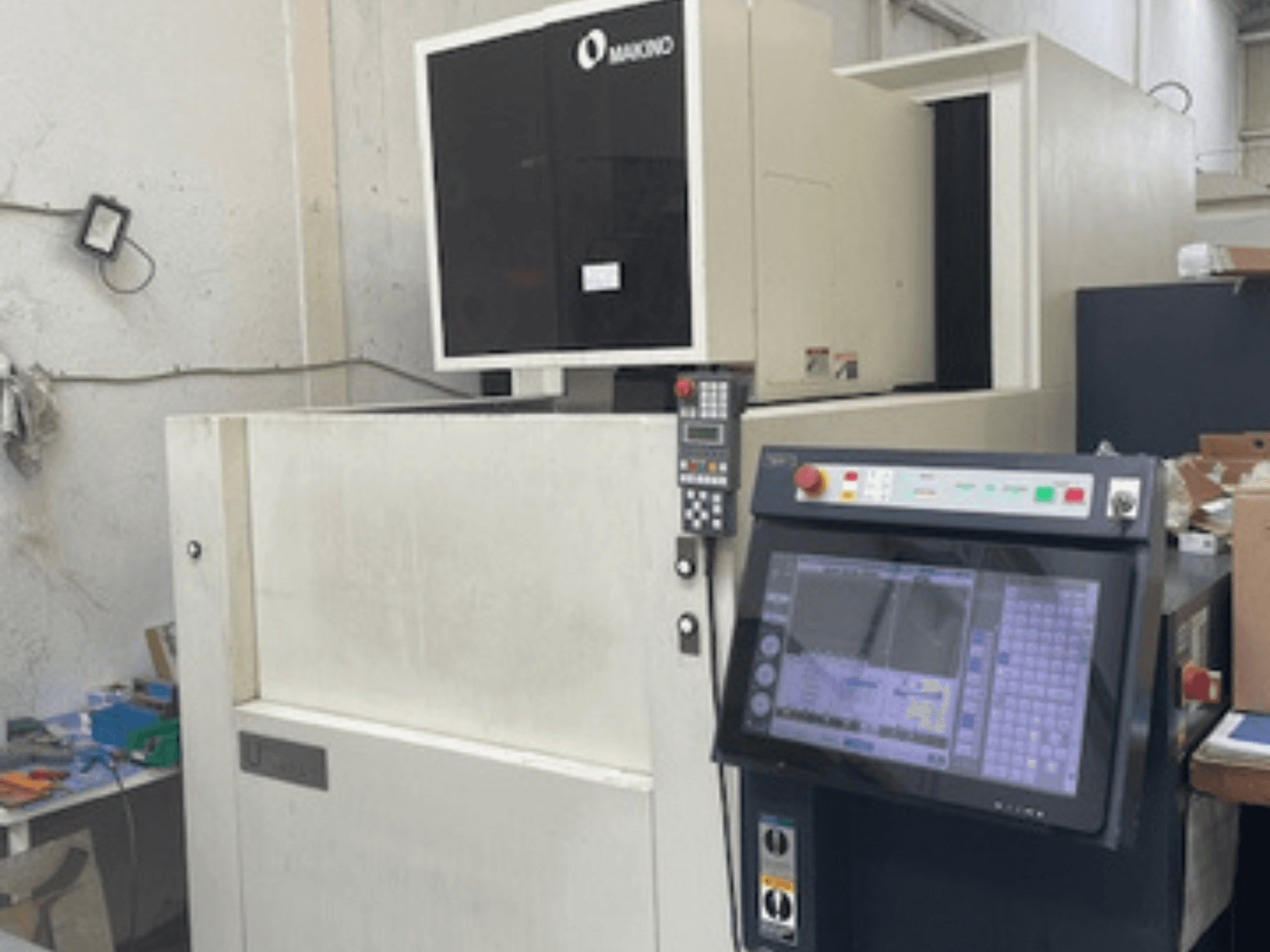 Drátový elektroerozivní stroj Makino U6 HEAT v dílně, pohled zepředu ukazuje ovládací panel a digitální displej.