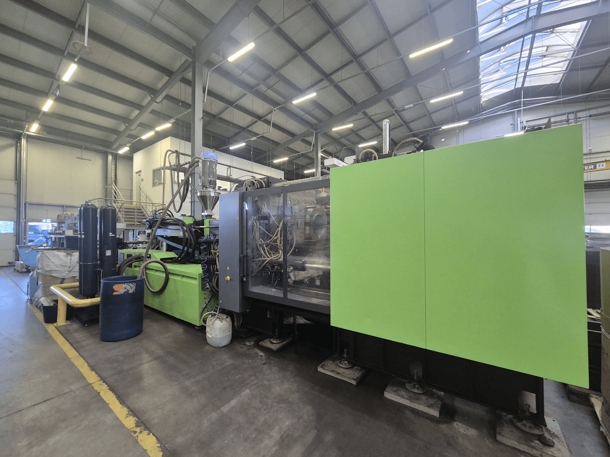 Hydraulický vstřikovací lis Engel duo 5160/700 v továrním prostředí, pohled z boku, s viditelným zeleným exteriérem a jednotlivými součástmi.