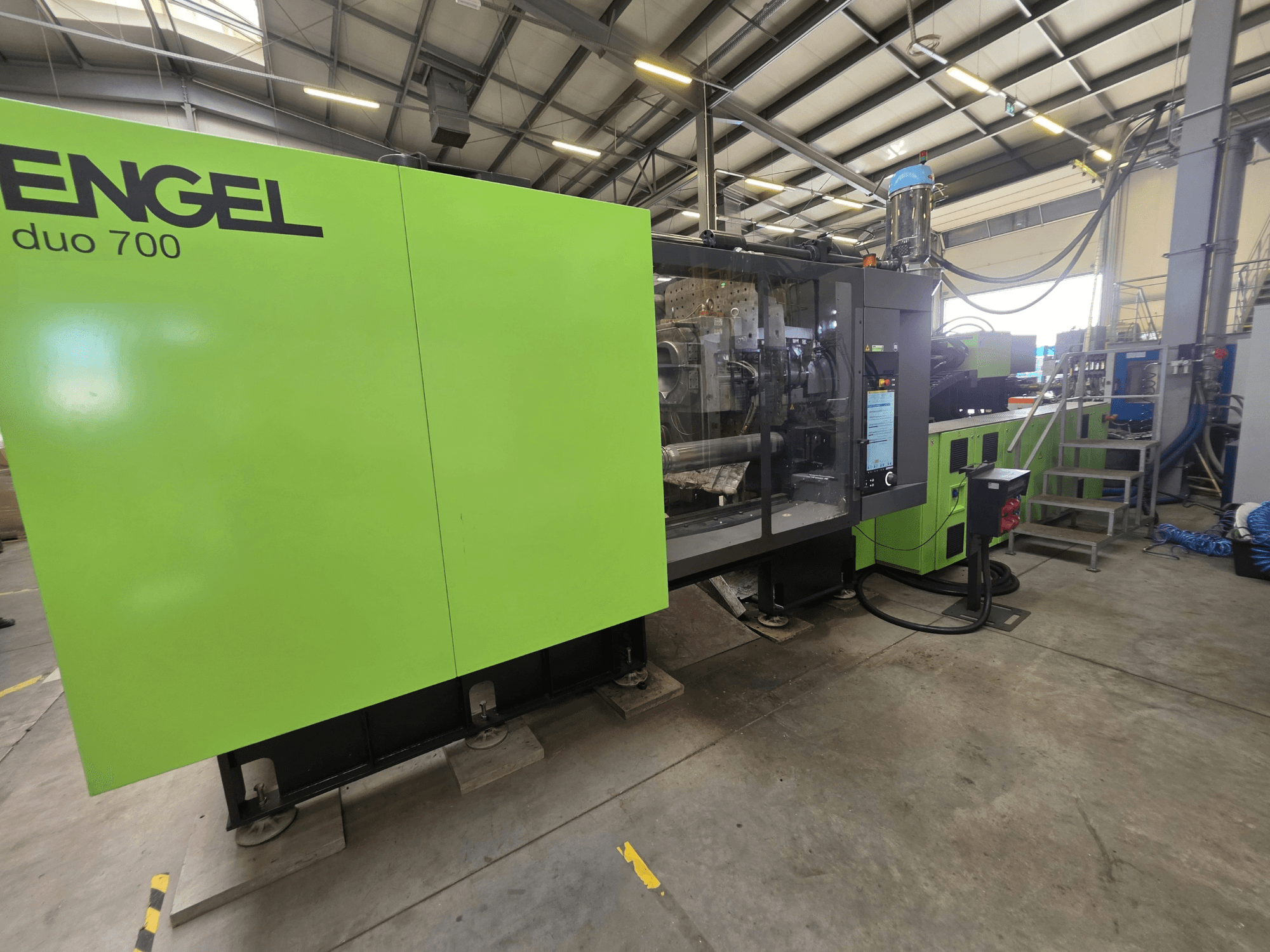 Hydraulický vstřikovací lis Engel duo 700, pohled zepředu, na snímku je vidět zelený plášť a ovládací panel.