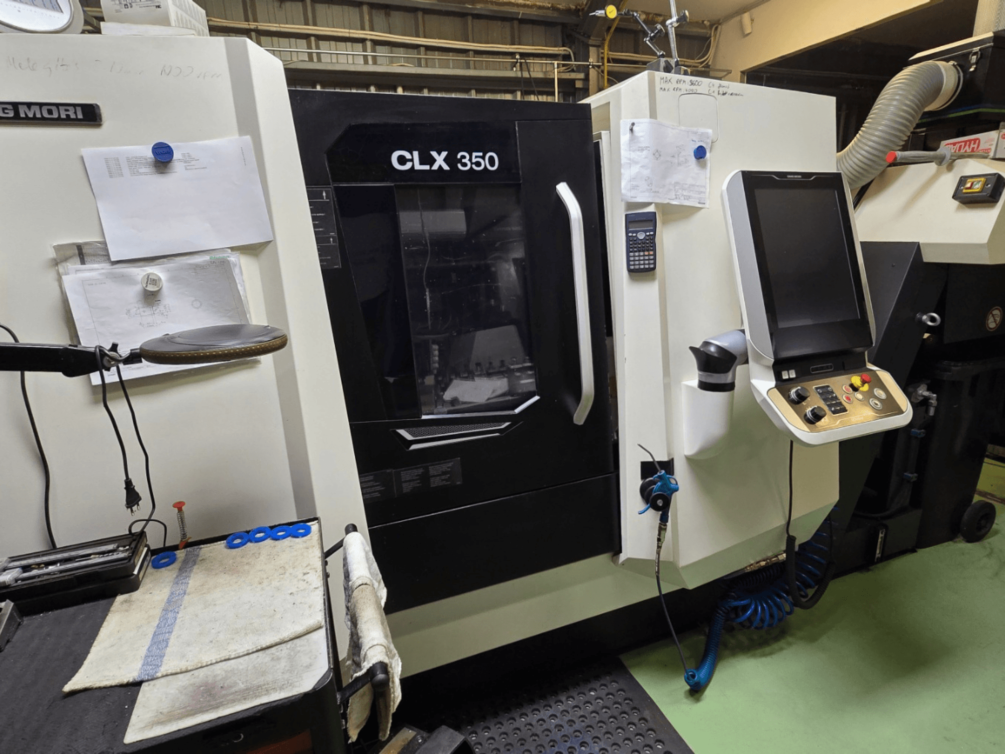 CNC soustruh DMG MORI CLX 350 v dílně; čelní pohled s viditelným ovládacím panelem, nástroji a pracovním prostorem.