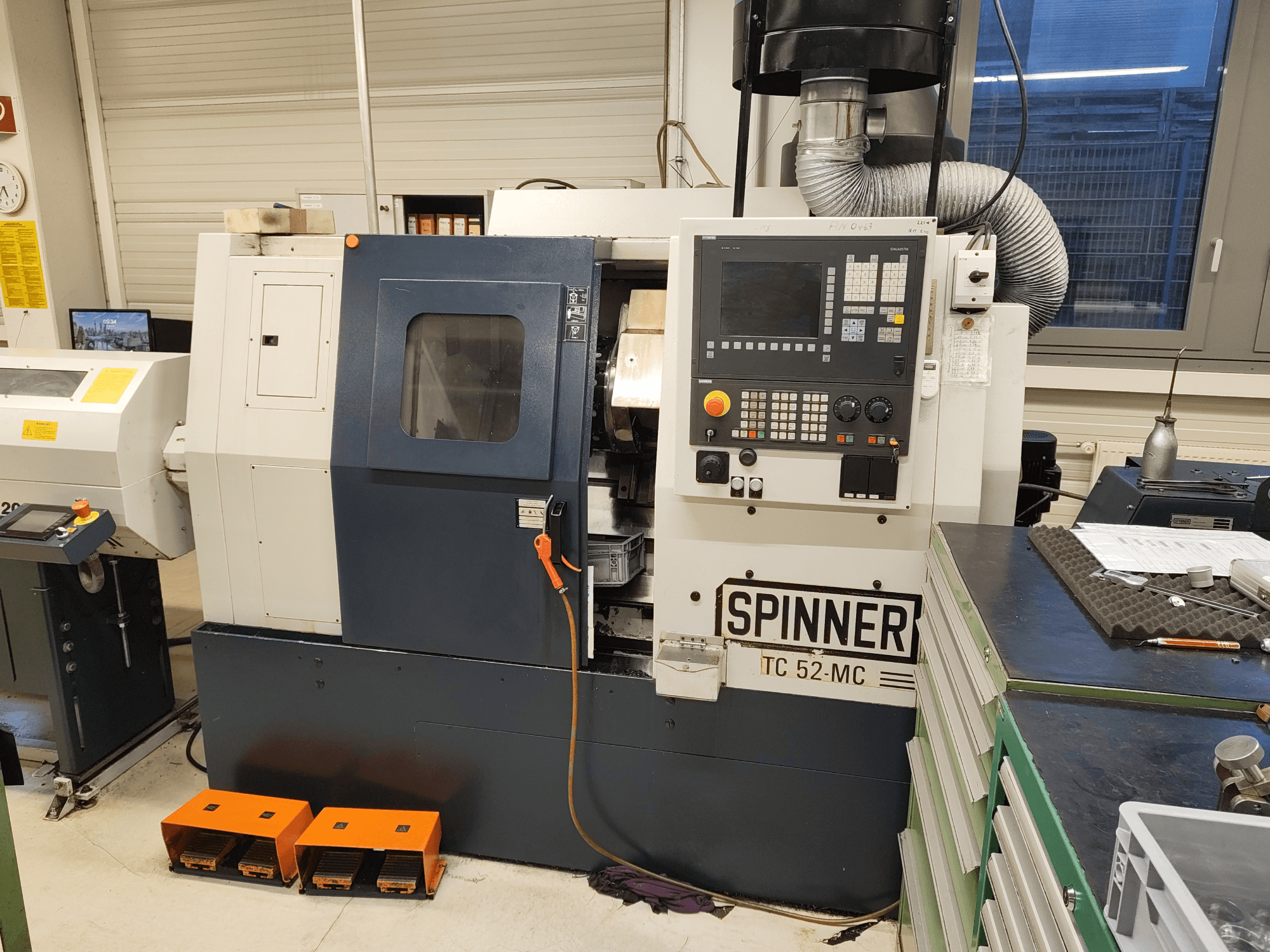 Horizontální soustruh SPINNER TC 52 MC v dílně, pohled zepředu, na kterém je vidět ovládací panel, obrobová zóna a bezpečnostní prvky.