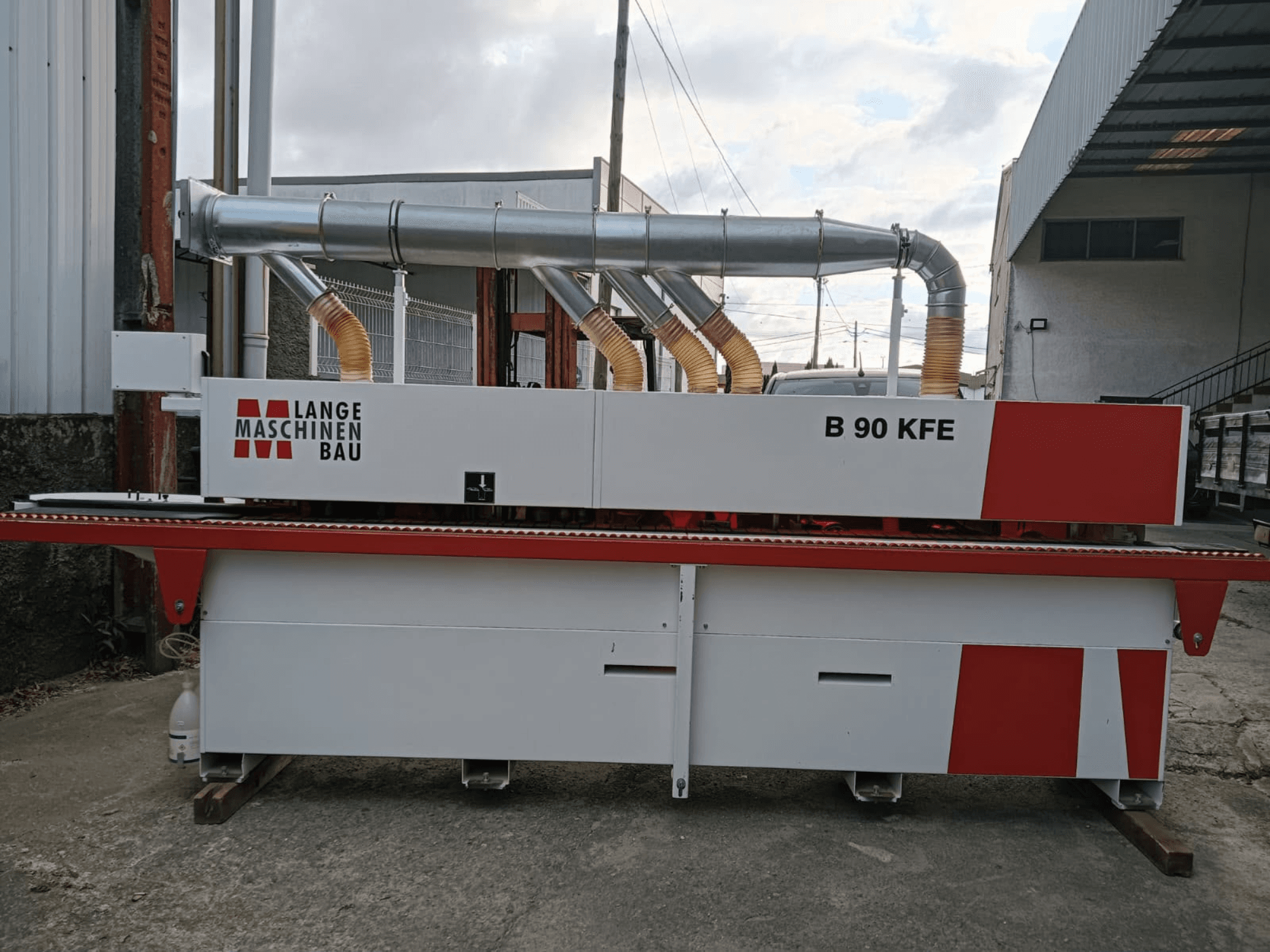 Olemovací stroj LANGE Maschinenbau B 90 KFE v bočním pohledu s dvojitými výfukovými trubkami a červenými akcenty, umístěný v průmyslovém pracovním prostoru.