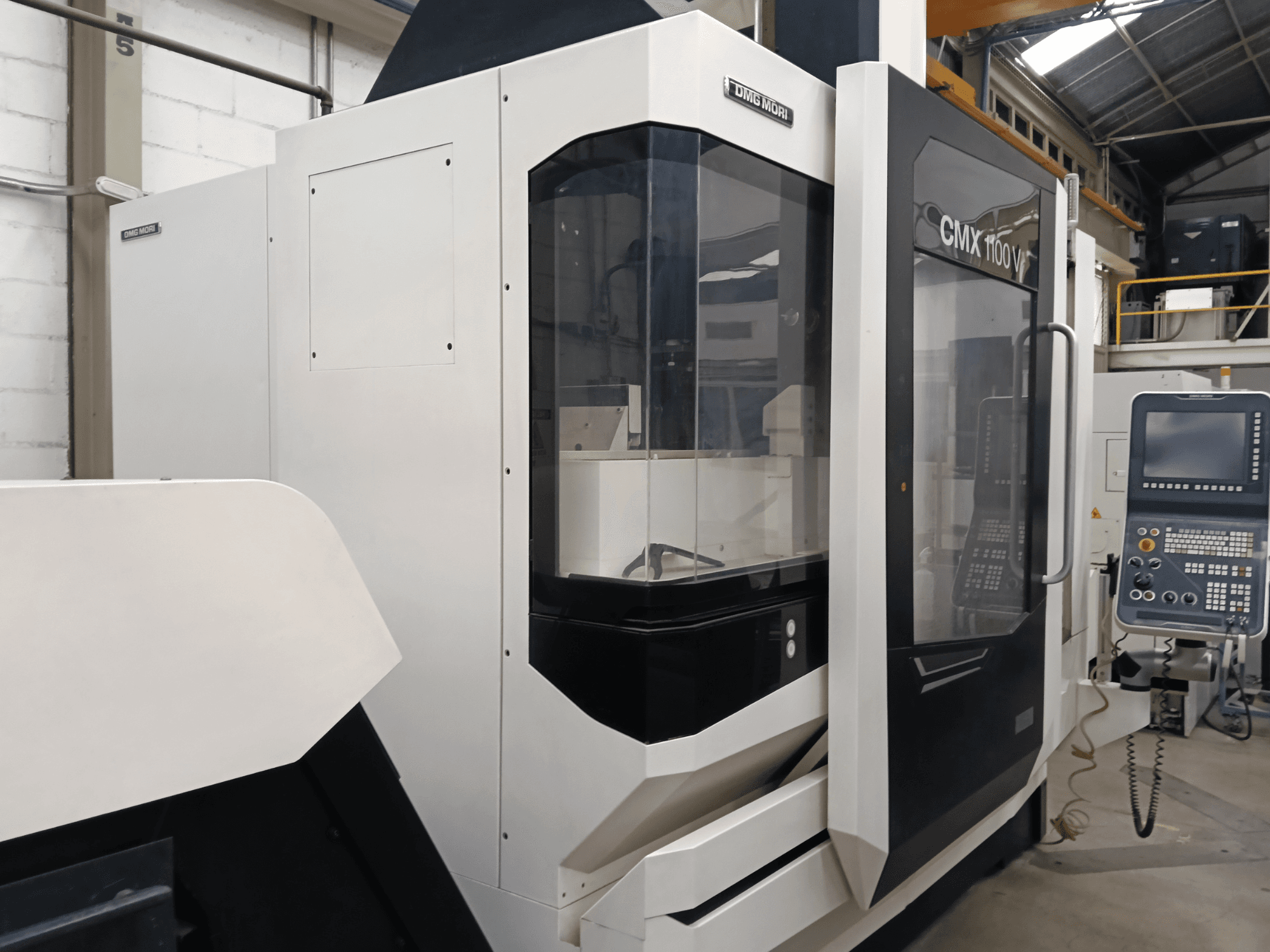 Vertikální obráběcí centrum DMG MORI CMX 1100 V, pohled zepředu, na kterém je vidět ovládací panel a skleněný kryt.