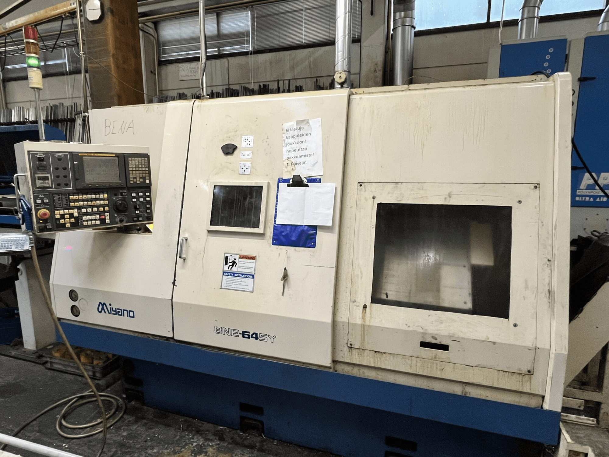 Soustruh Miyano BNE-64SY CNC, pohled zepředu, ovládací panel s tlačítky, LCD a nálepky pro údržbu na skříni.