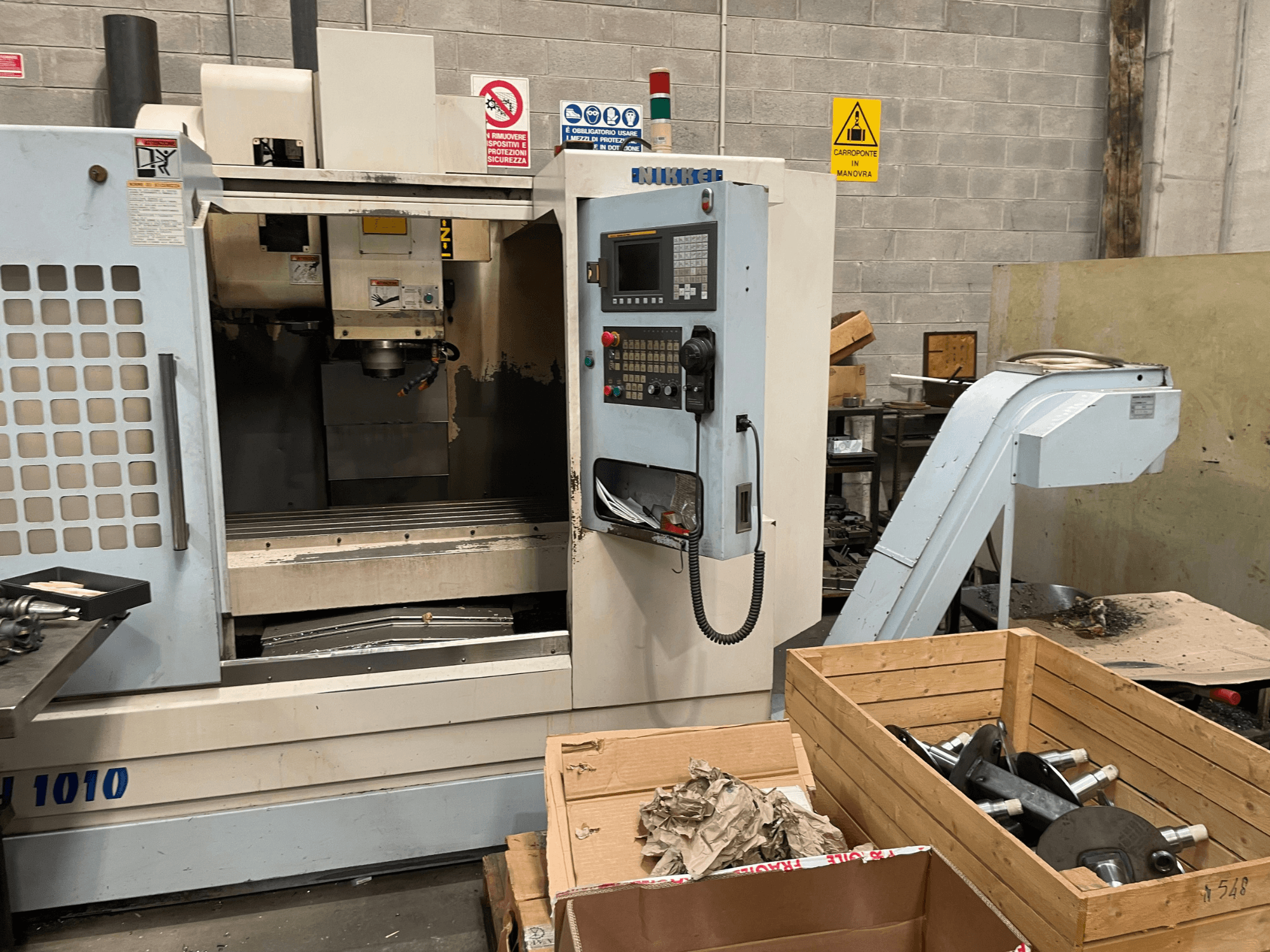 Vertikální obráběcí centrum od společnosti Other, model VH-1010, pohled zepředu s viditelnými ovládacími prvky a skříňkami v blízkosti.