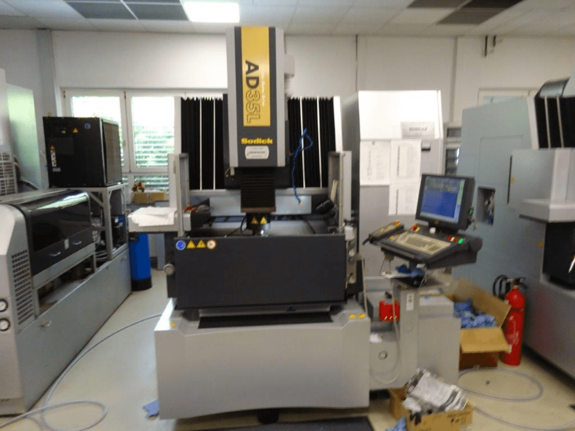 CNC stroj Sodick AD35L z čelního pohledu, s ovládacím panelem, chladicí jednotkou a bezpečnostními ukazateli.