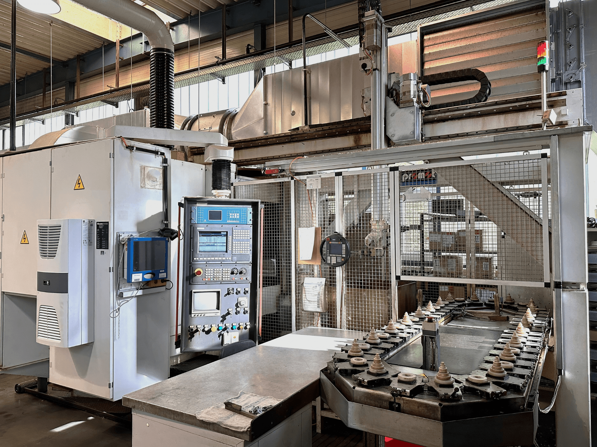 Průmyslové stroje s ovládacím panelem, chladicí jednotkou a dopravníkem. Pohled zepředu s jasnými světly a bezpečnostním značením.