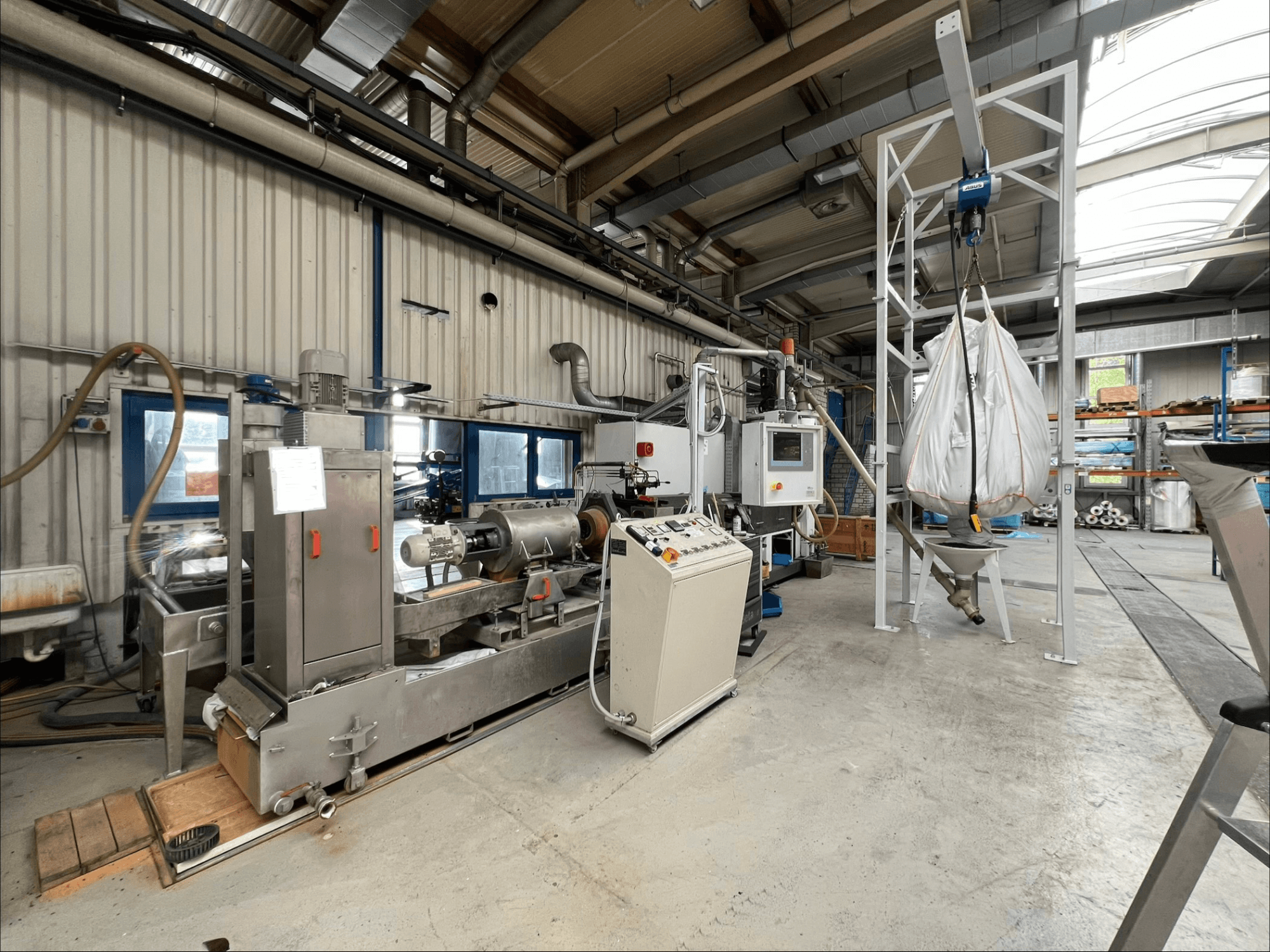 Pohled zepředu na stroj na zpracování plastů FILTEC GRP 350 v průmyslovém prostředí, s ovládacími prvky a podávacím systémem.