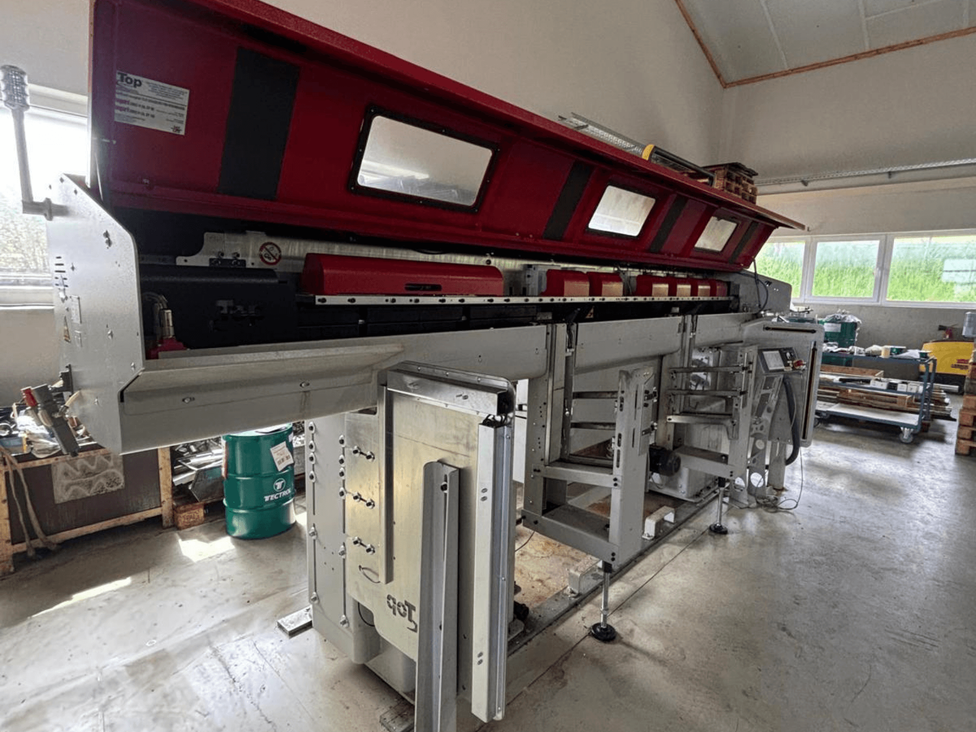 TOP Automazioni – model Top Loader ETL 10-75 zobrazený z boku, s červenou horní částí a složitými mechanickými součástmi.