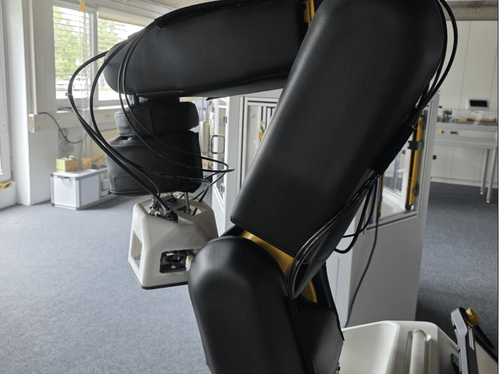 Boční pohled na kolaborativního robota FANUC LR Mate 200iD/7L, na kterém je vidět rameno a senzory; v prostředí dílny jsou vidět kabely.