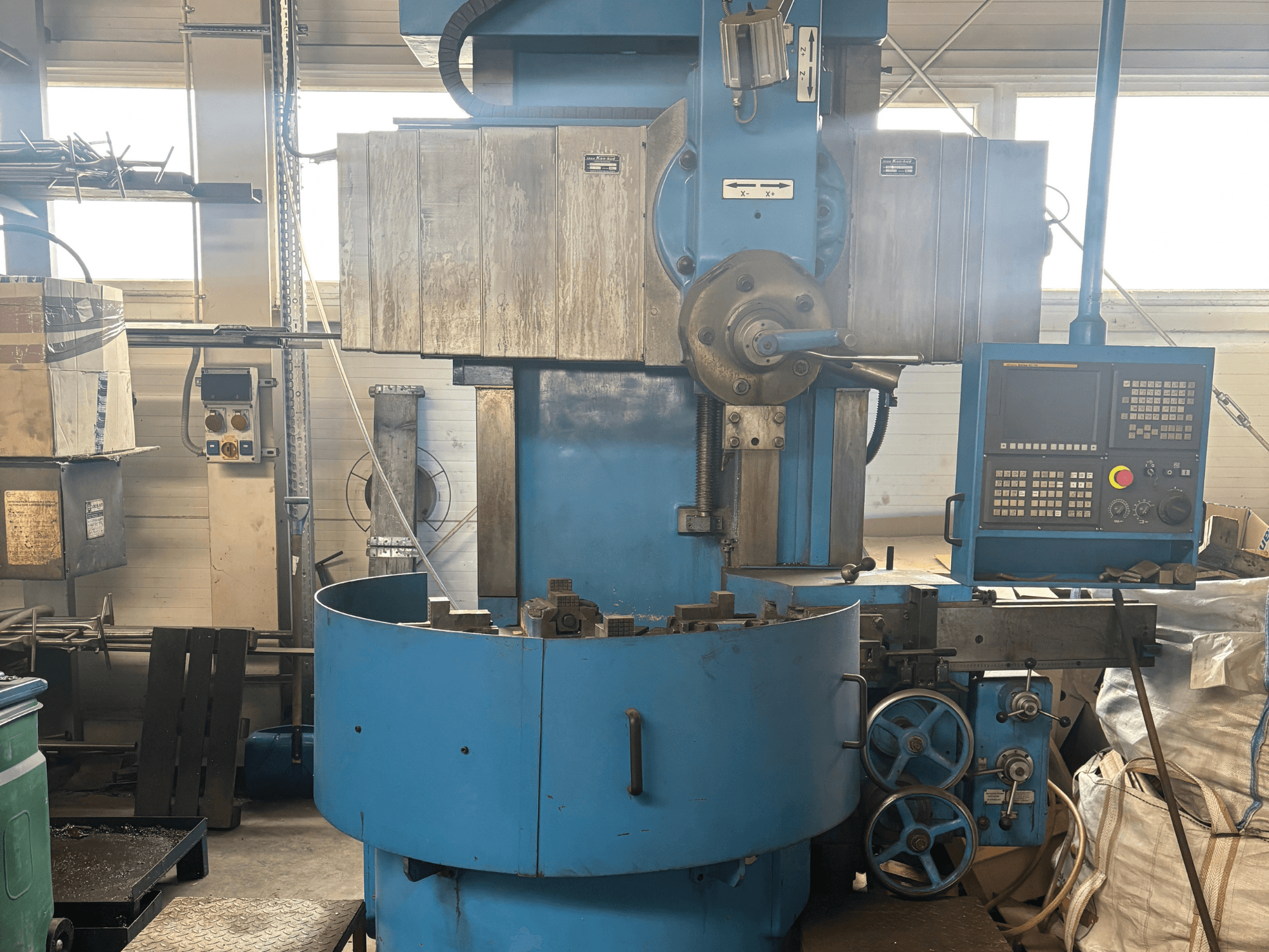 Průmyslová frézka neznámé značky, pohled zepředu, s modrým vnějším povrchem a digitálním ovládacím panelem.