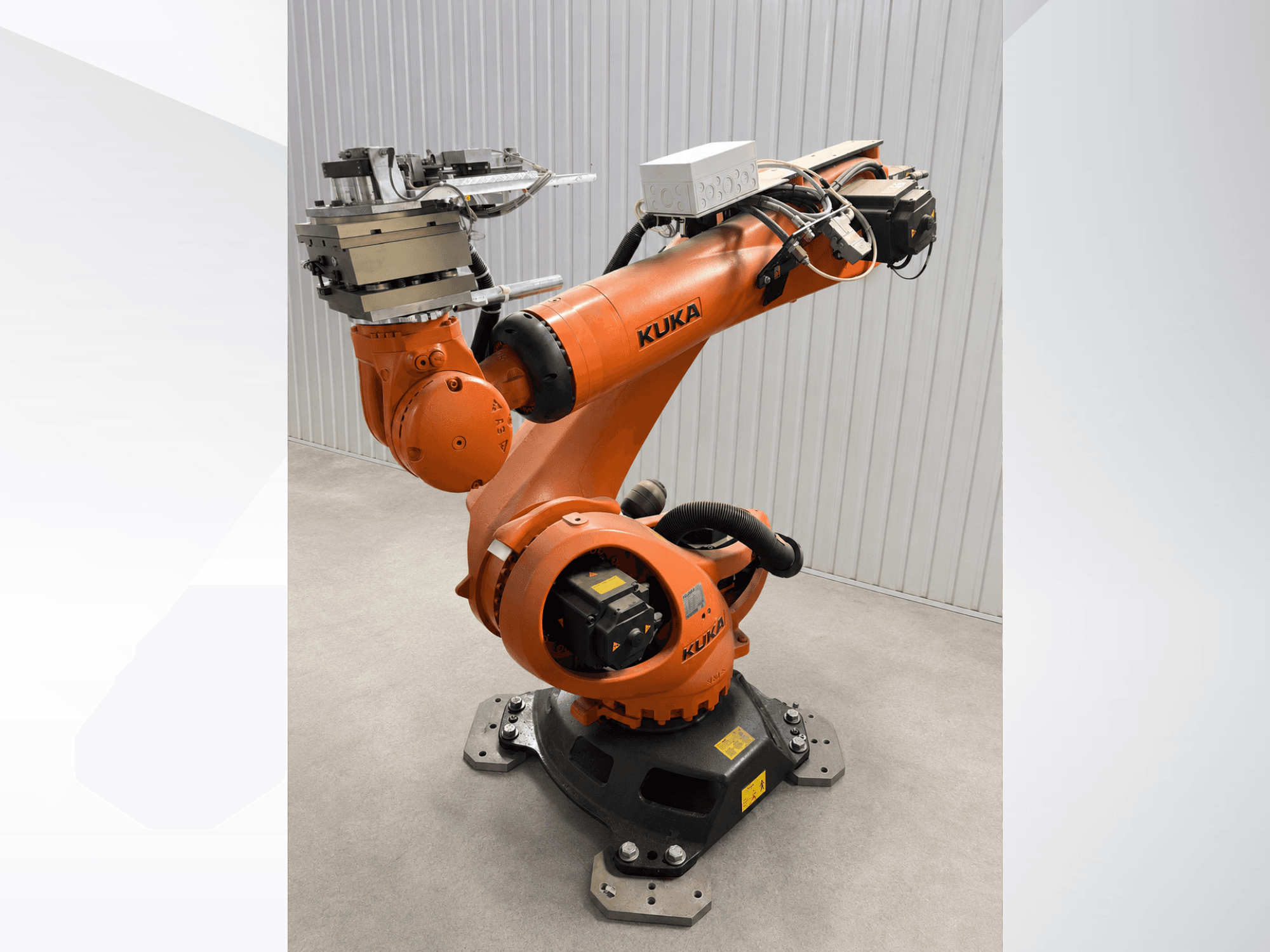 Náhradní robotické rameno KUKA KR 90 R3100 v oranžové barvě, pohled z boku, znázorňující klouby, řídicí jednotku a upevnění nástroje na koncovém efektoru.