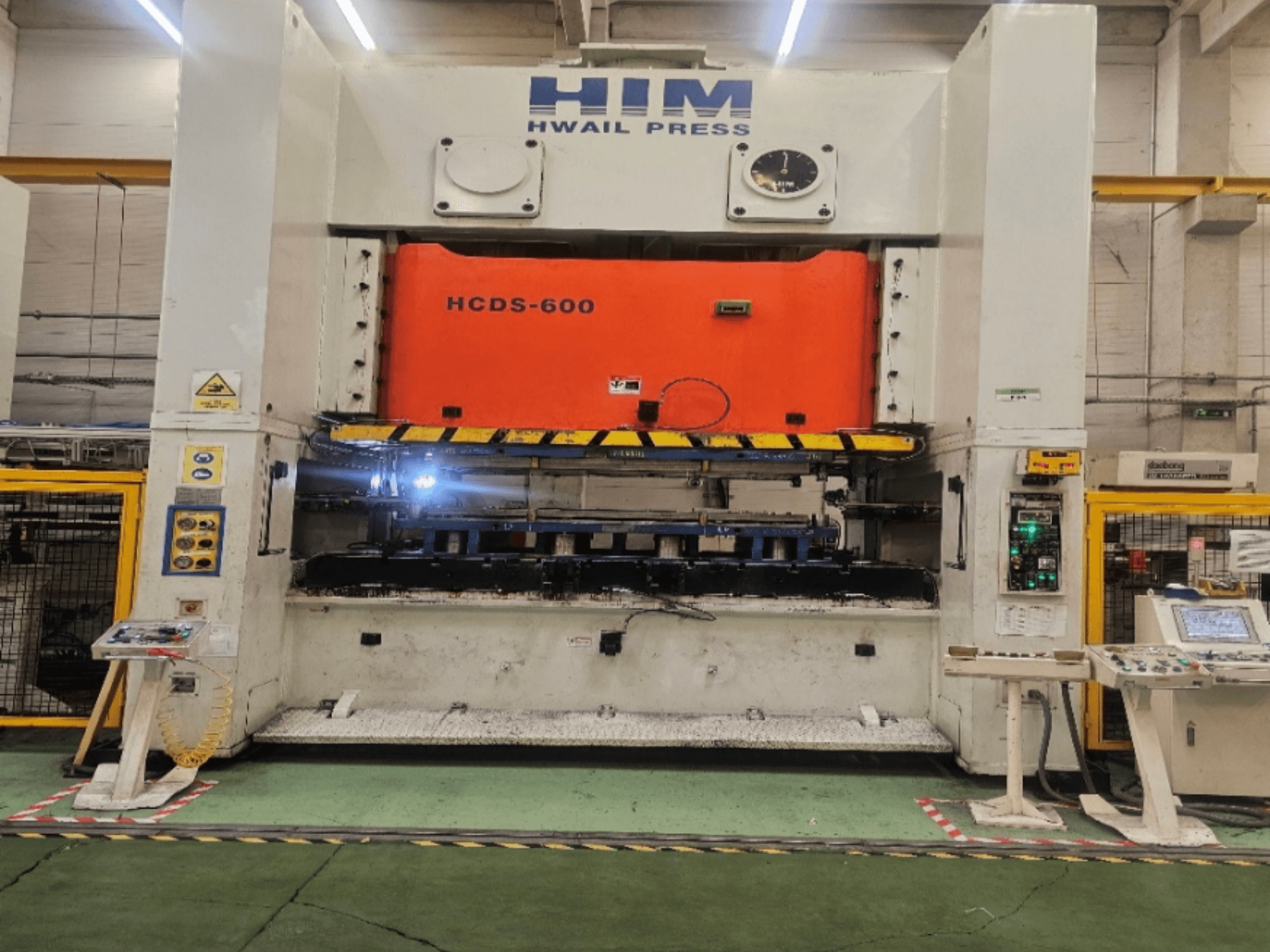 Pohled zepředu na mechanický lis HIM HWAIL PRESS HCDS-600 s oranžovou lisovací deskou a ovládacím panelem.
