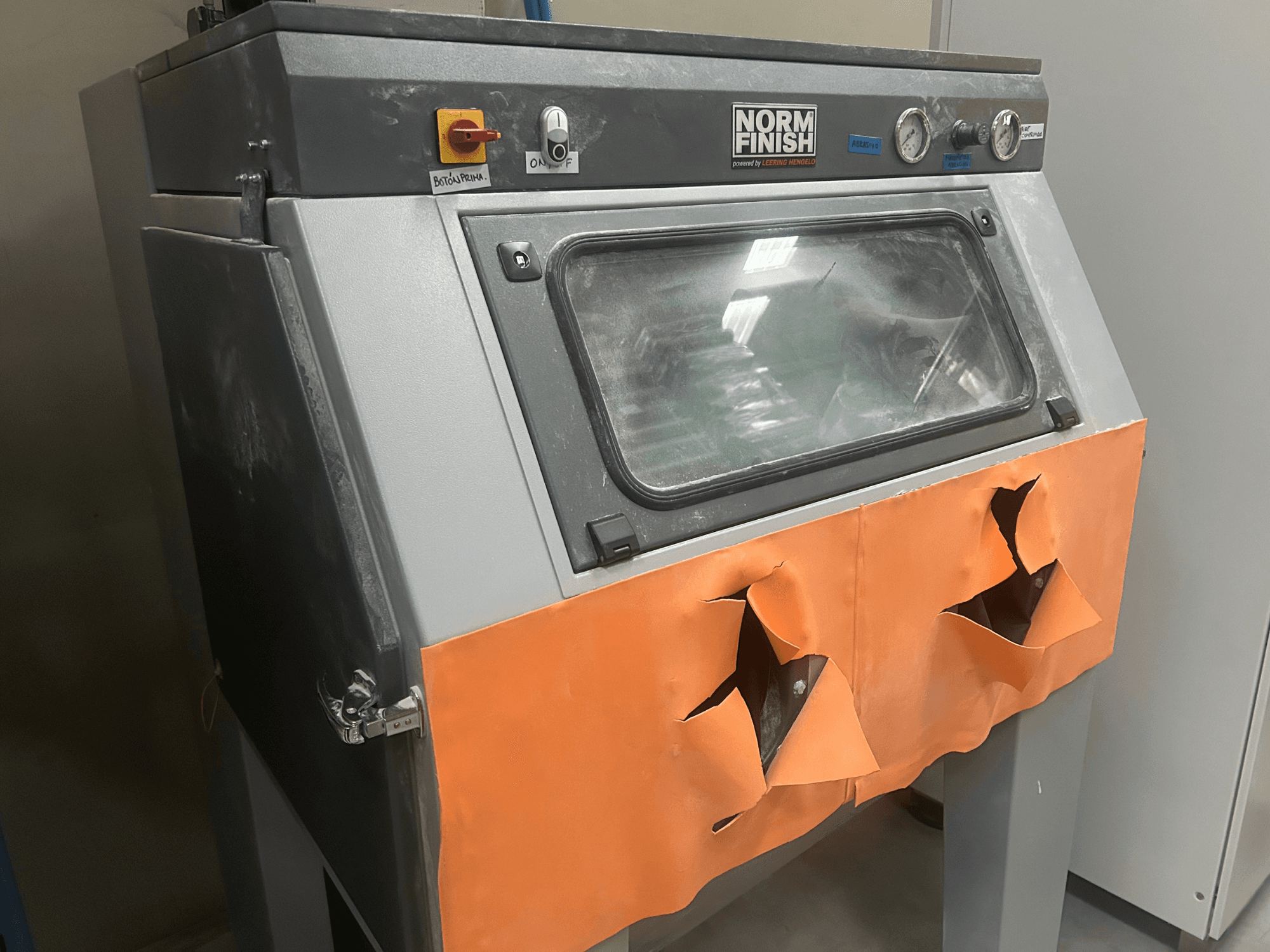 Plastová 3D tiskárna EOS P 396 v šedé barvě, boční pohled s opotřebovaným oranžovým krytem a viditelným ovládacím panelem, zaprášený stav.