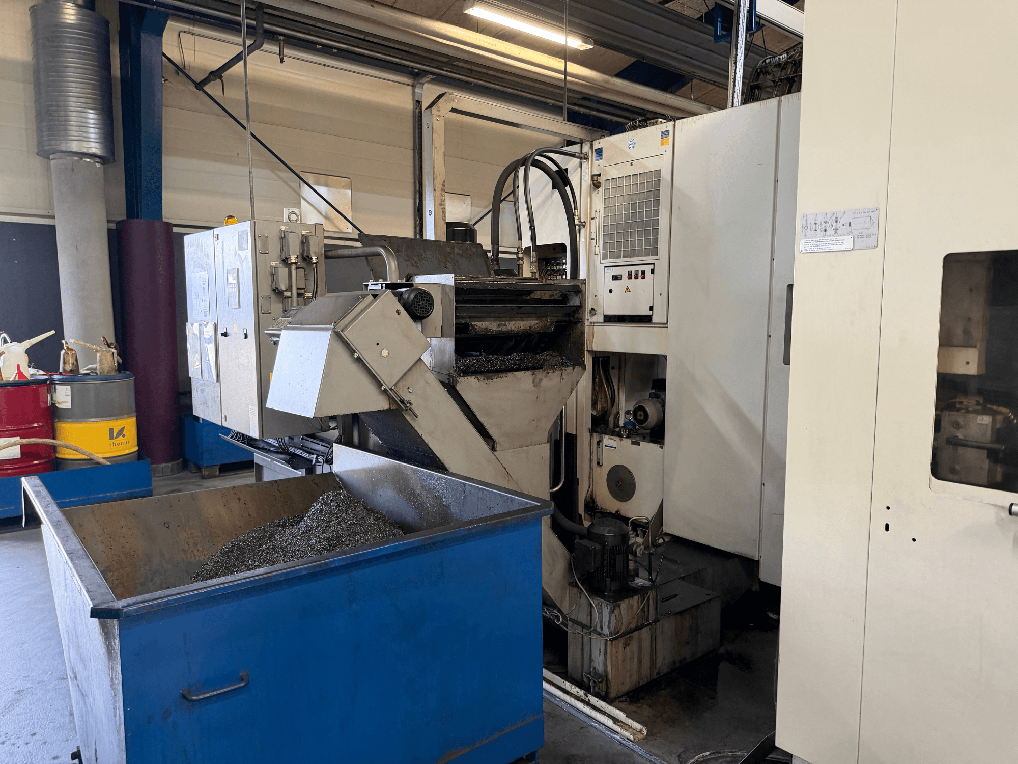 Pohled zepředu na horizontální obráběcí centrum HELLER MCH 250 s viditelným zásobníkem chladicí kapaliny a ovládacím panelem.