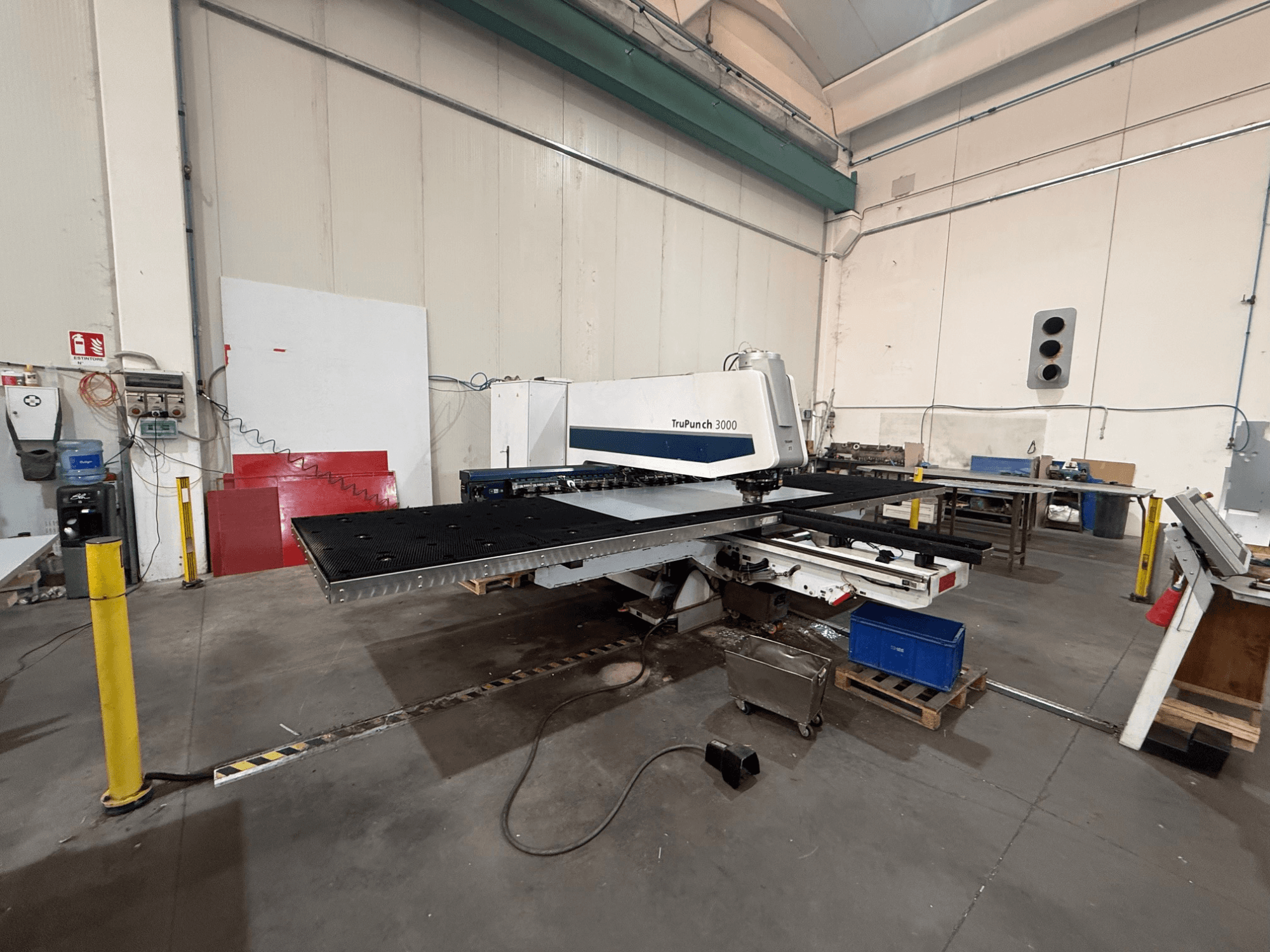 CNC děrovací stroj TRUMPF TruPunch 3000, pohled z boku, na kterém je vidět děrovací hlava, velký stůl a okolní prostředí dílny.