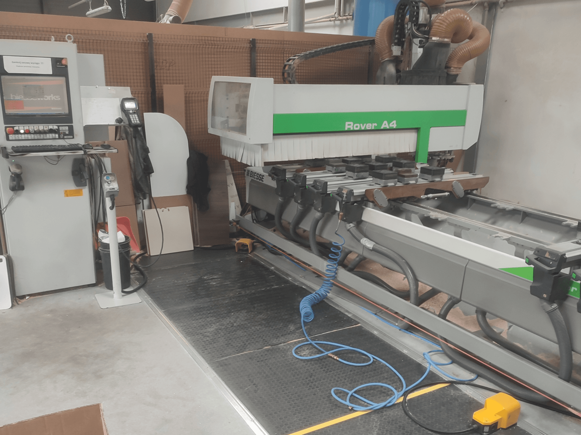 CNC centrum pro obrábění dřeva BIESSE Rover A4 v bočním pohledu, na kterém je vidět ovládací panel, vakuové upínací prvky a systém odsávání prachu.