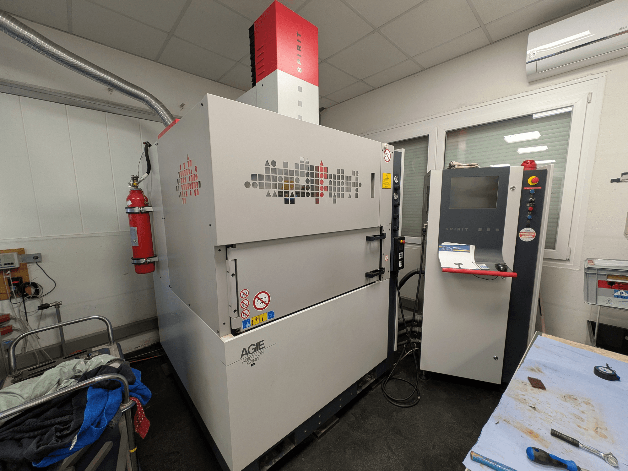 Hloubicí elektroerozivní stroj AGIE AGIETRON SPIRIT 3, boční pohled, ovládací panel a hasicí přístroj.