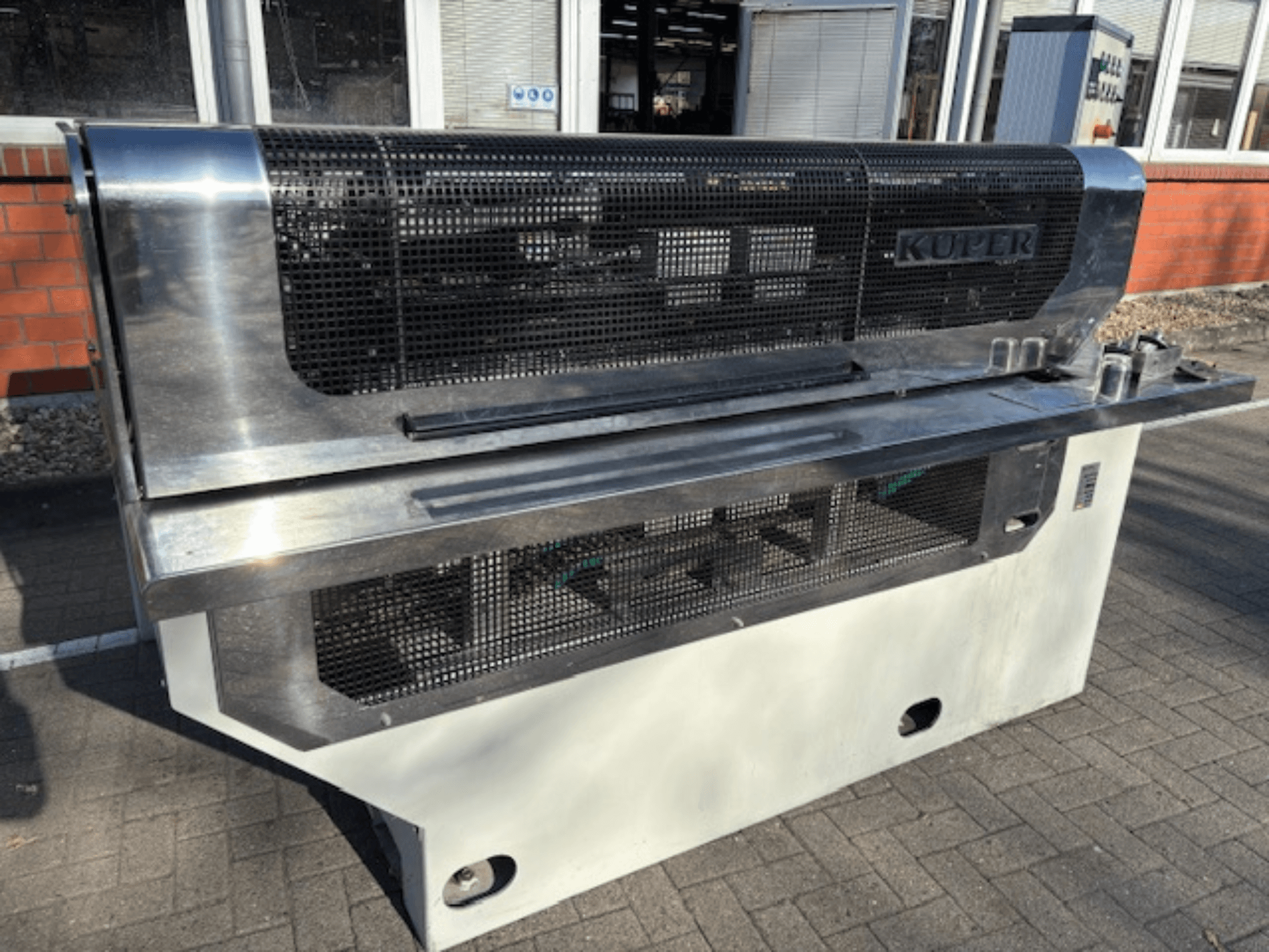 Gilotina na dýhy KUPER FLI, pohled zepředu, s tělem z nerezové oceli a ochrannou sítí pro bezpečný provoz.