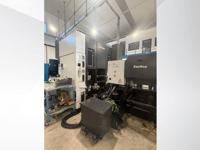 Obráběcí centrum Okuma s jednotkou ConSep, boční pohled, zobrazení ovládacích prvků a průmyslové nastavení, včetně zásobníku kovových třísek.