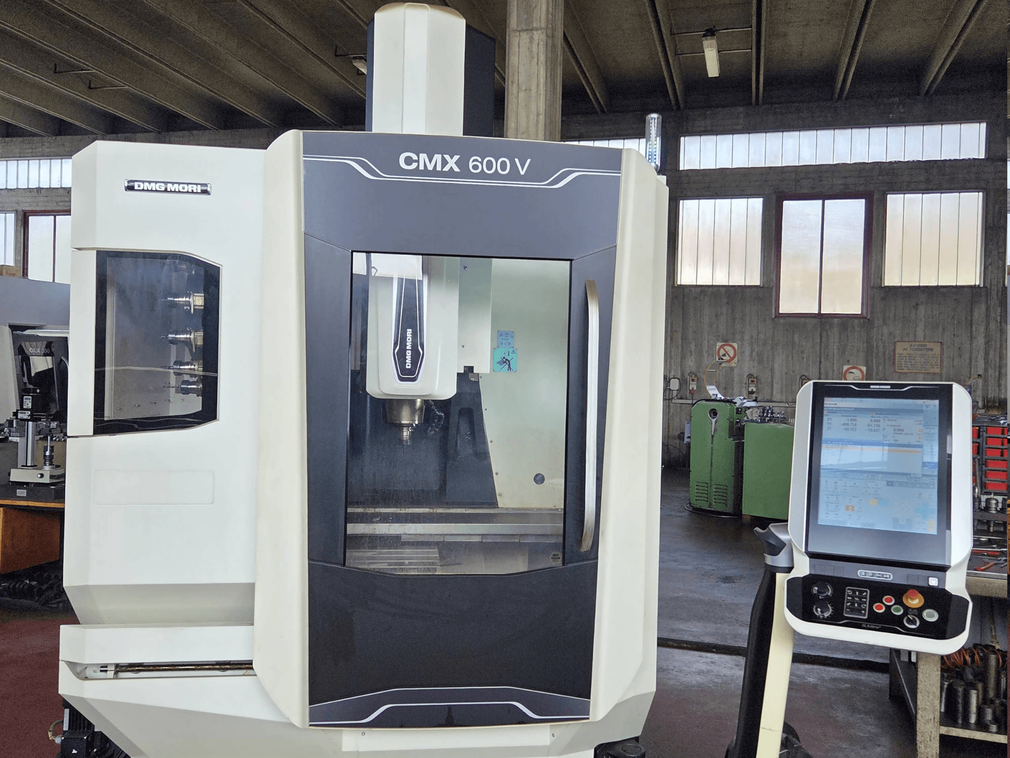 Vertikální obráběcí centrum DMG MORI CMX 600V v čelním pohledu, s detailním záběrem na ovládací panel a oblast vřetena.