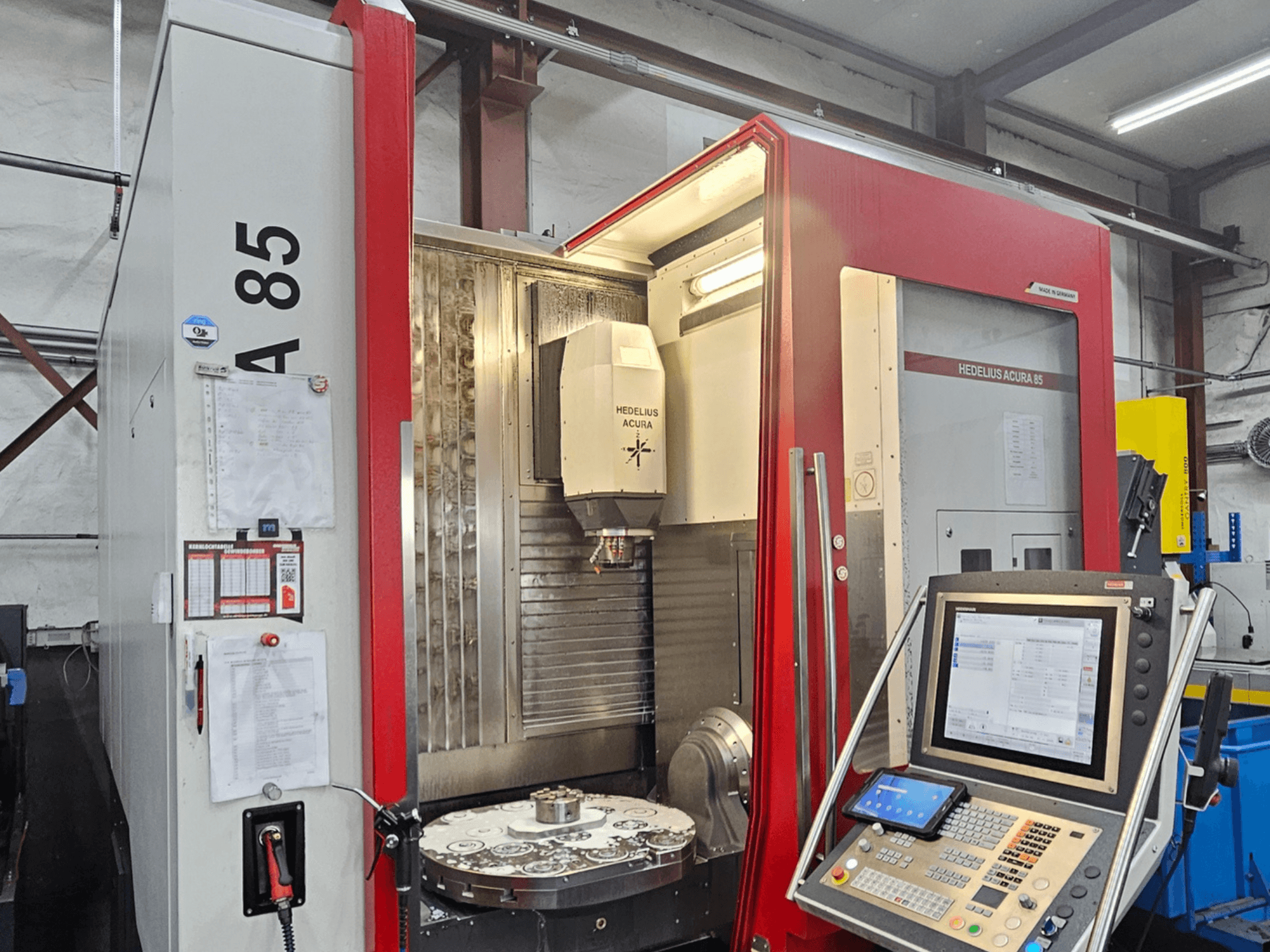 Vertikální obráběcí centrum HEDLIUS Acura 85, pohled zepředu, s ovládacím panelem a otočným stolem pro přesné obrábění.