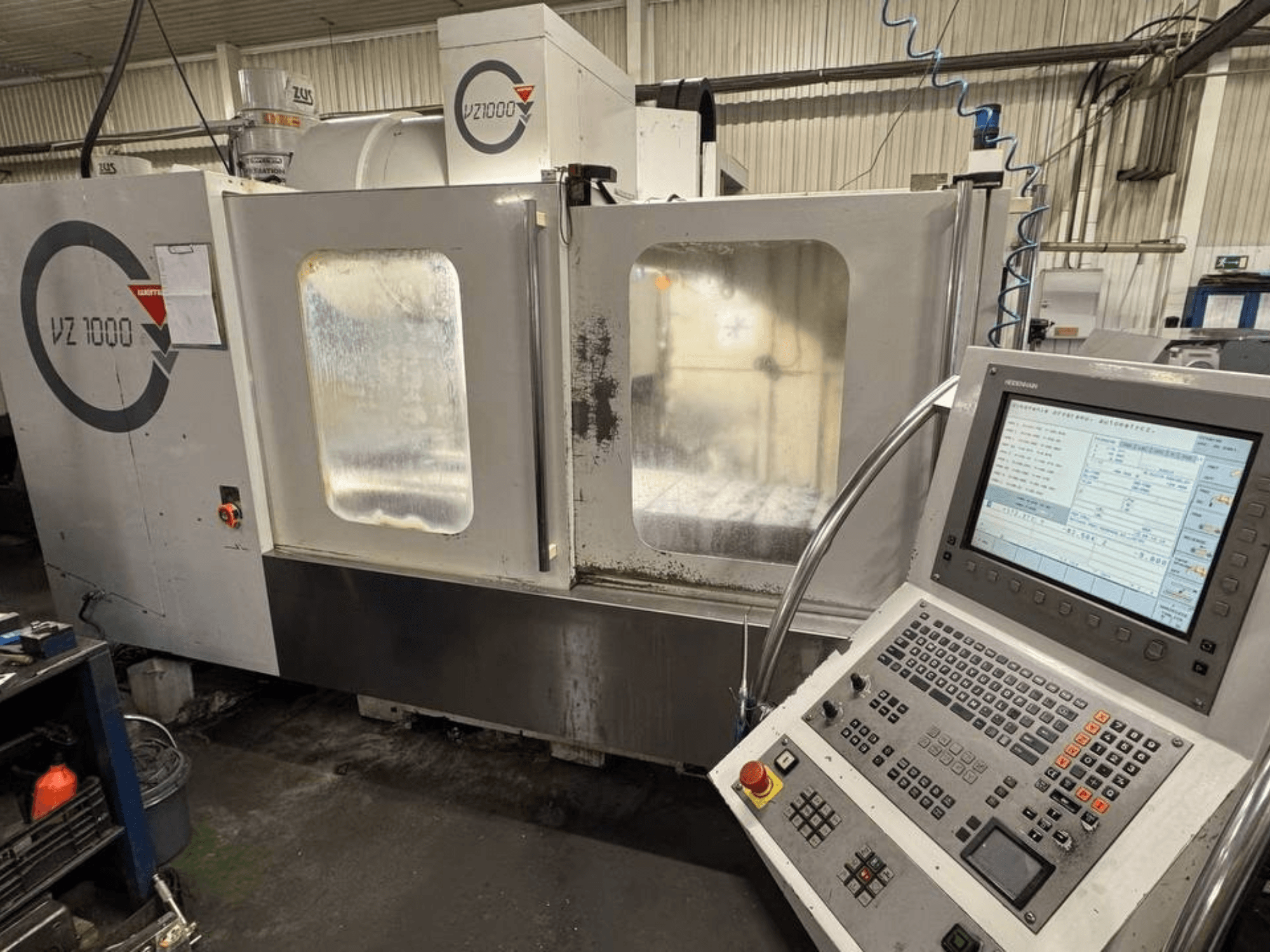 Pohled zepředu na vertikální obráběcí centrum WEMAS VZ 1000 s ovládacím panelem a průhlednými přístupovými dveřmi.