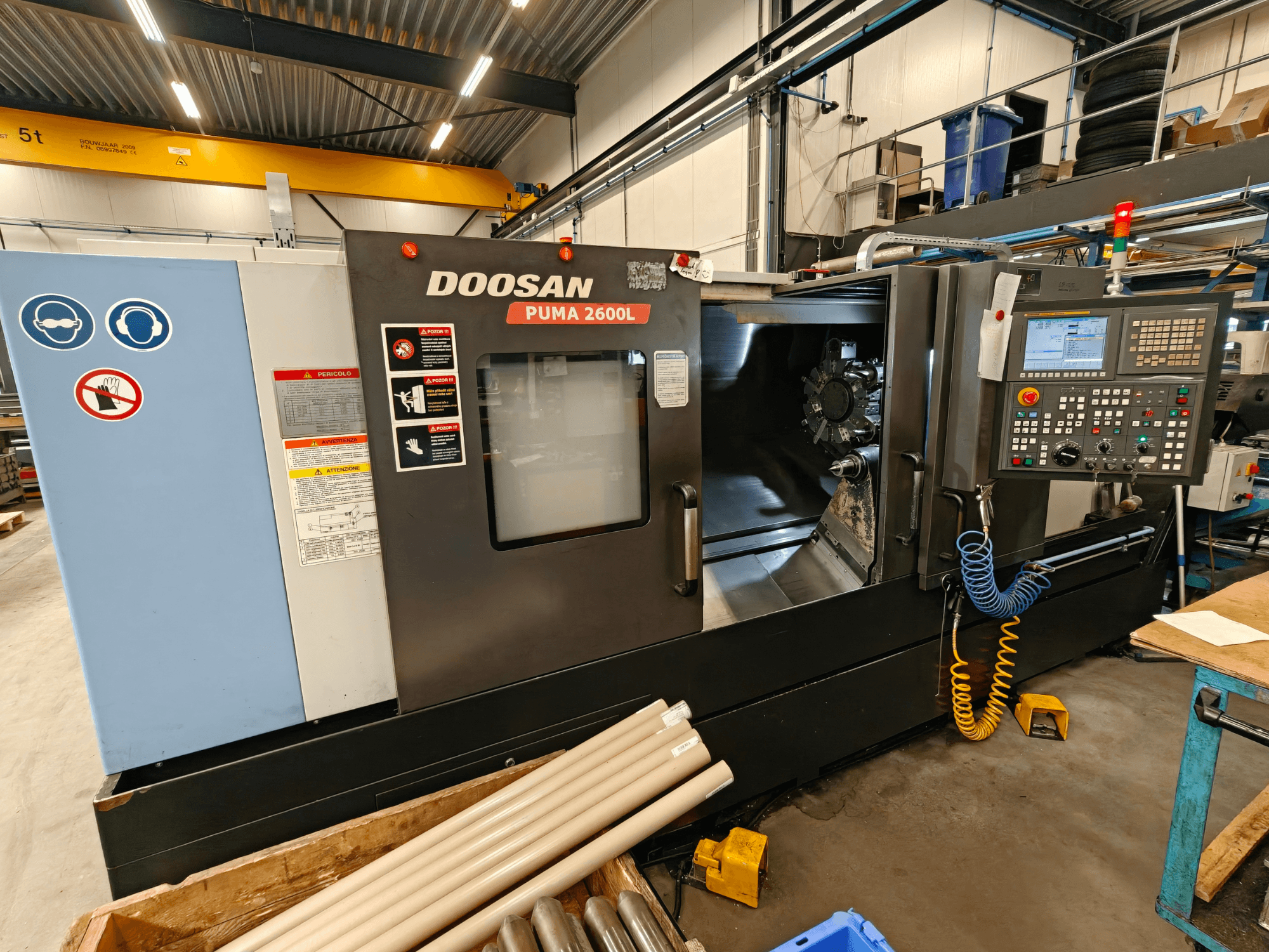 Horizontální soustruh DOOSAN Puma 2600L v dílně, boční pohled ukazuje ovládací panel a prostor vřetena.
