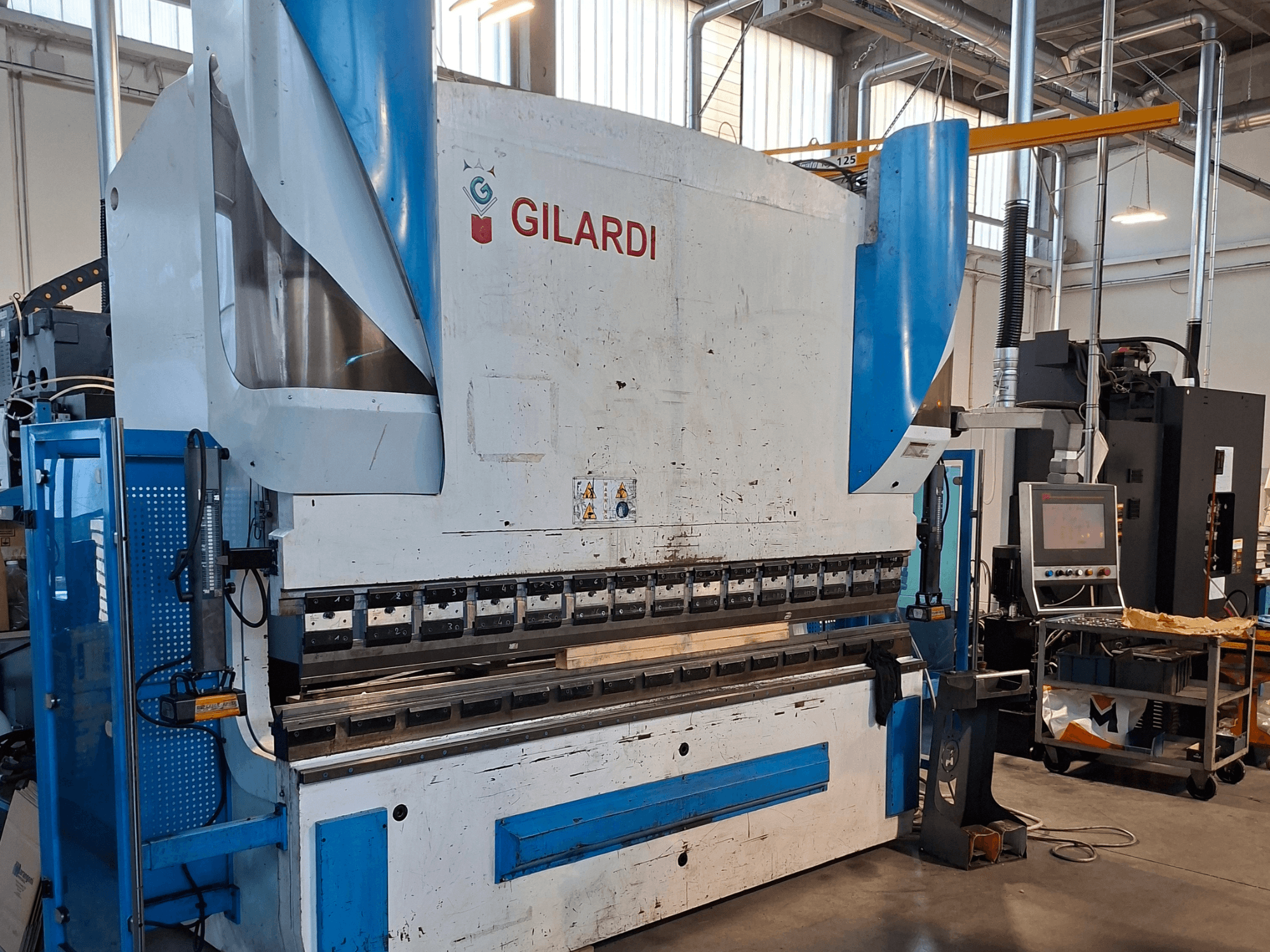 Hydraulický lis GILARDI Italy 3,25, pohled zepředu, znázorňující ovládací prvky a detaily výrobního prostředí.
