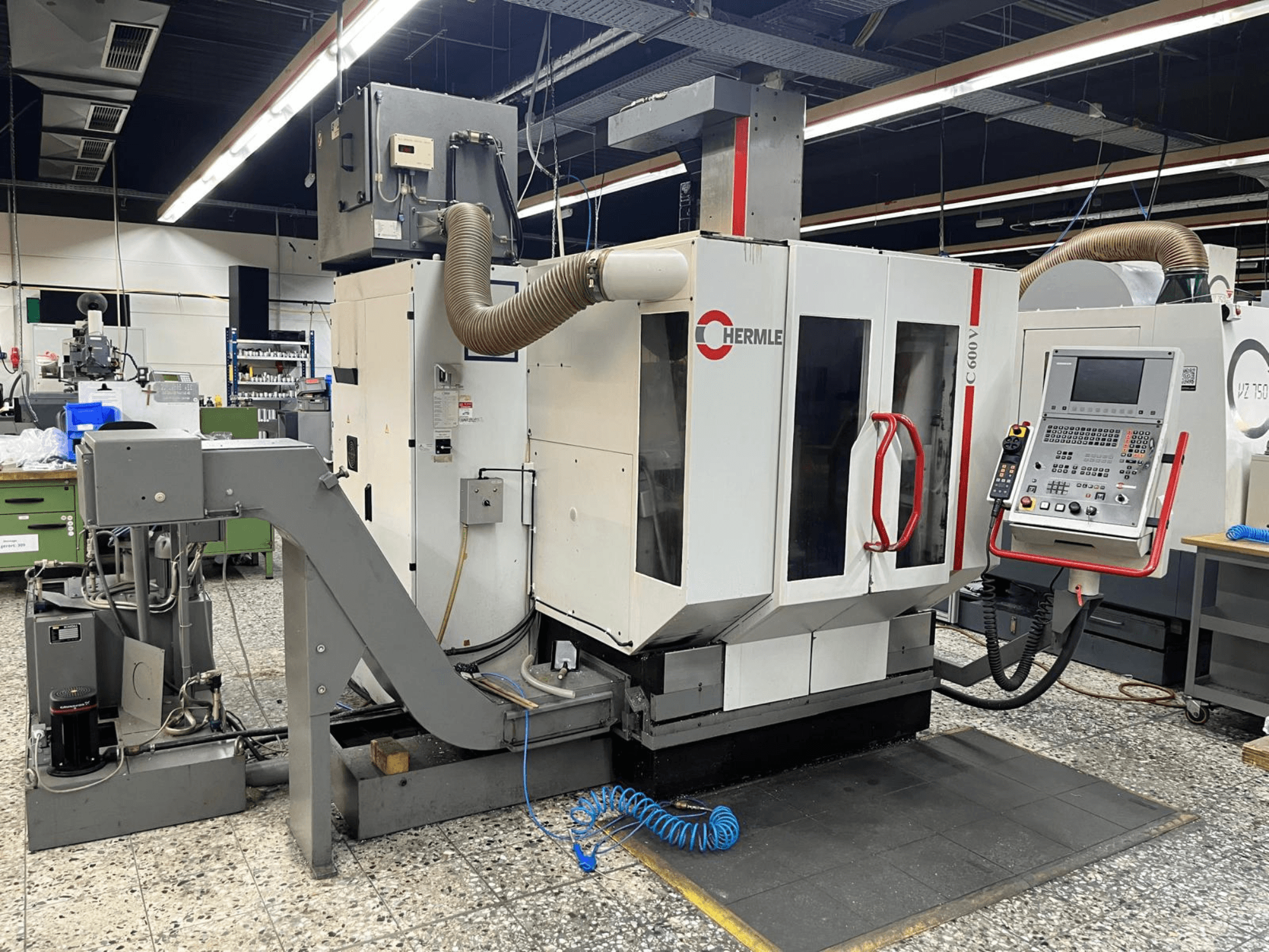 Vertikální obráběcí centrum HERMLE C 600 V v dílně, čelní pohled ukazuje ovládací panel a ventilační prvky.