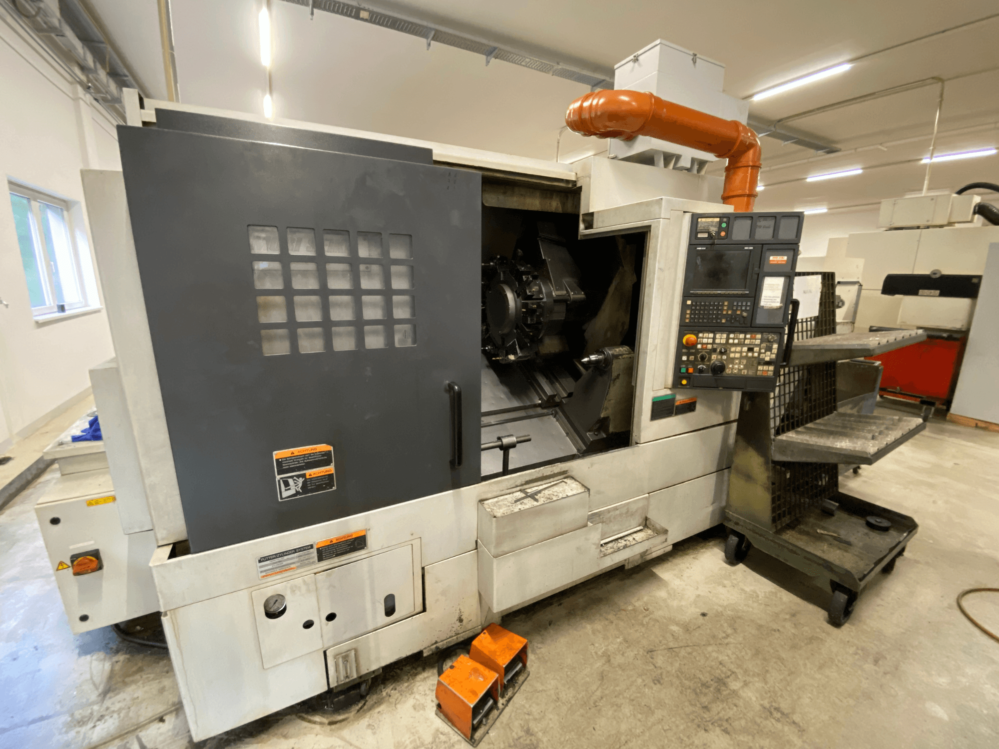 Frézovací a soustružnické centrum DMG Mori Seiki NL2500Y/700, pohled zepředu znázorňující ovládací panel a detaily krytu stroje.
